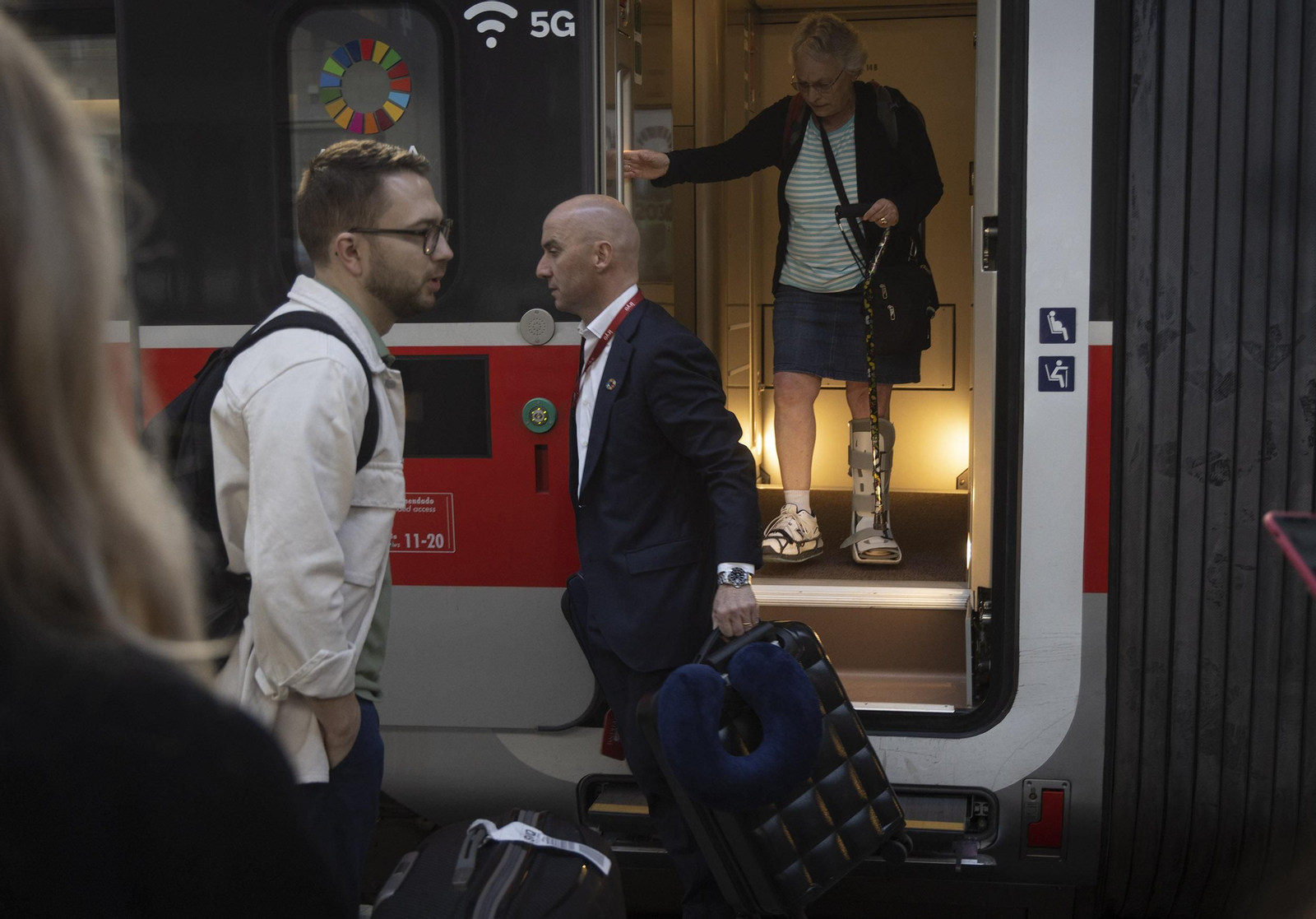 Gorini ayuda a una pasajera con su maleta minutos antes de partir el tren.