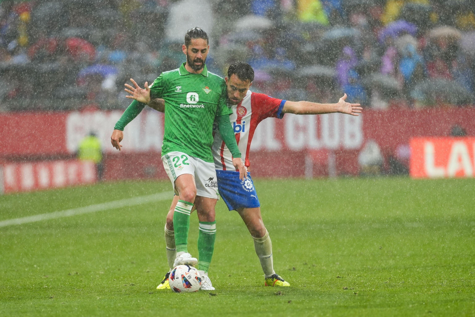 Isco protege el balón presionado por un rival.