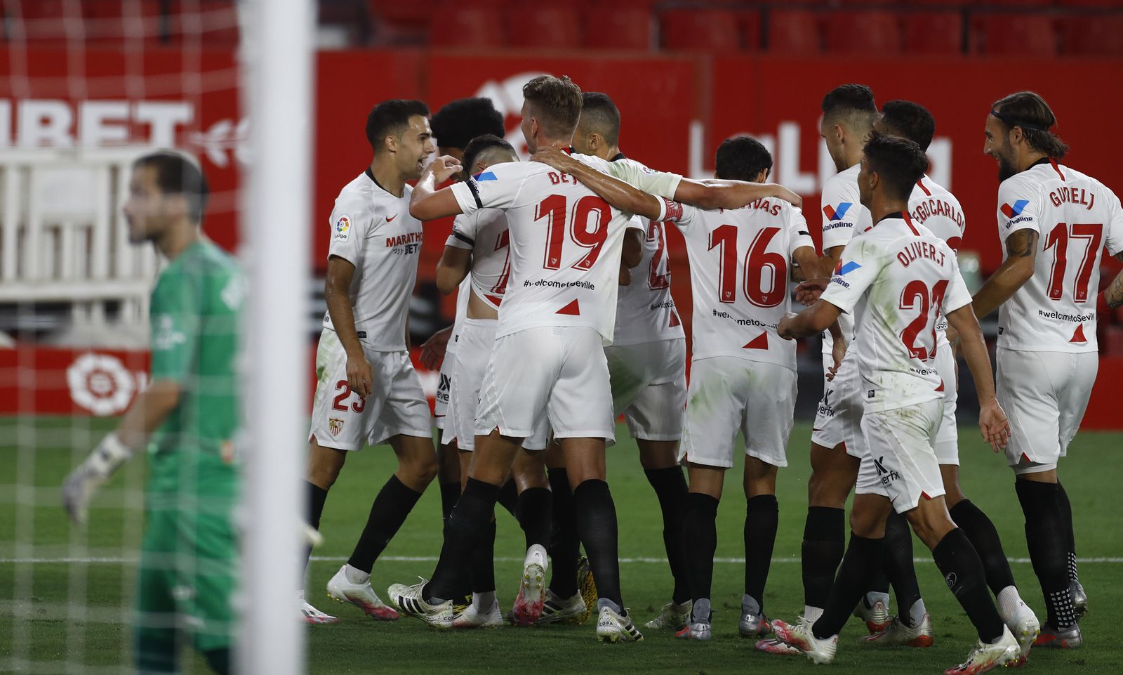 Los futbolistas del Sevilla se abrazan para celebrar el gol de Reguilón.