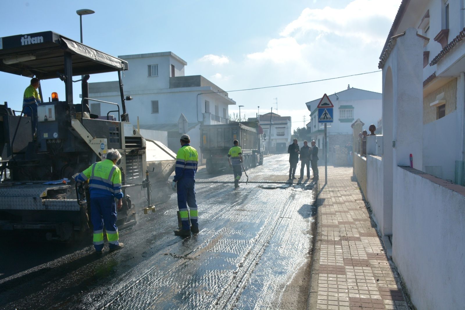 Operarios trabajan con la máquina de asfaltado en la calle Molino de la Estación.