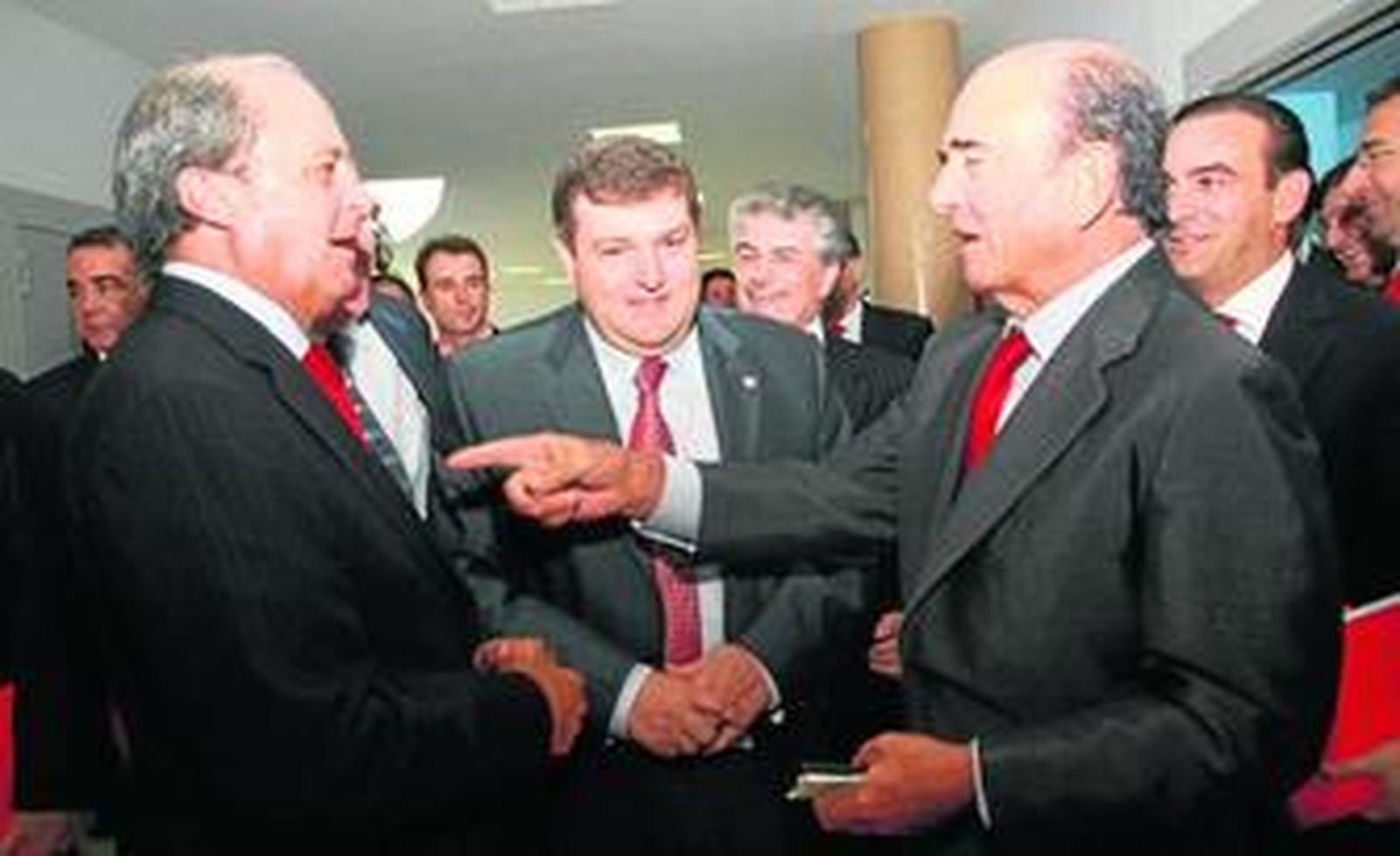 Ponce y Botín bromean sobre el color rojo de las corbatas, corporativo del Santander, en la presencia del rector de la Universidad de Huelva.