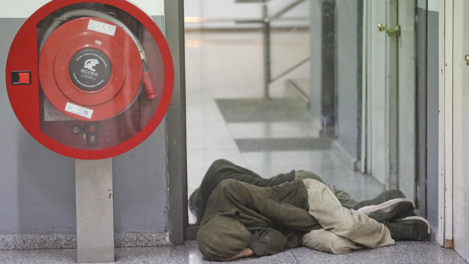 Un hombre duerme en las instalaciones del aeropuerto.
