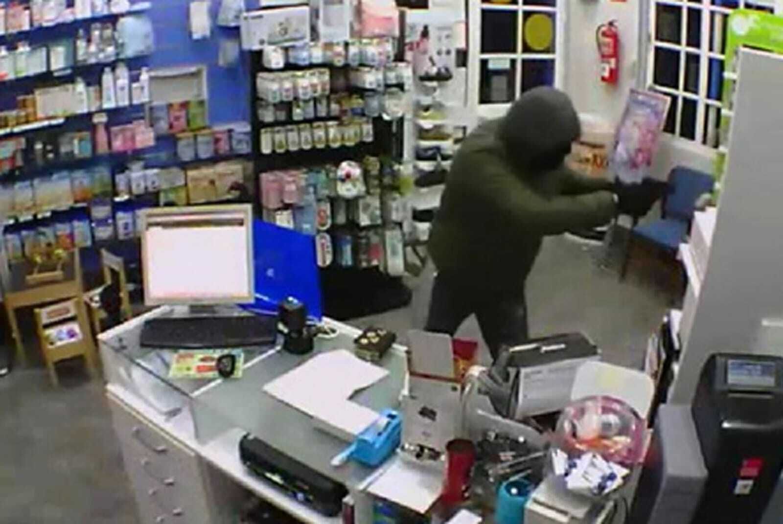 El detenido apunta con una pistola a los empleados de una farmacia de Brenes.