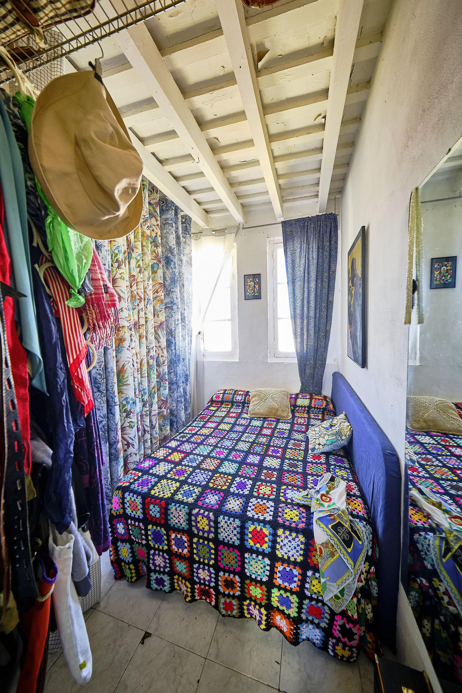 En el dormitorio, diferentes retales de telas junto a una gran colcha de lana limitan y protagonizan el espacio.