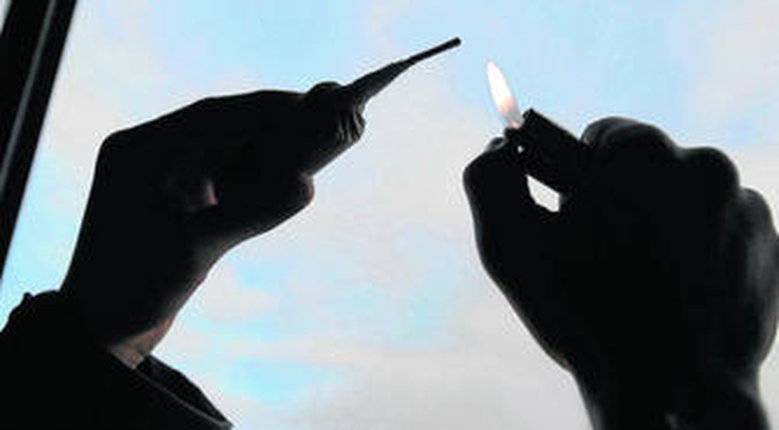 Un hombre enciende un petardo con un mechero.