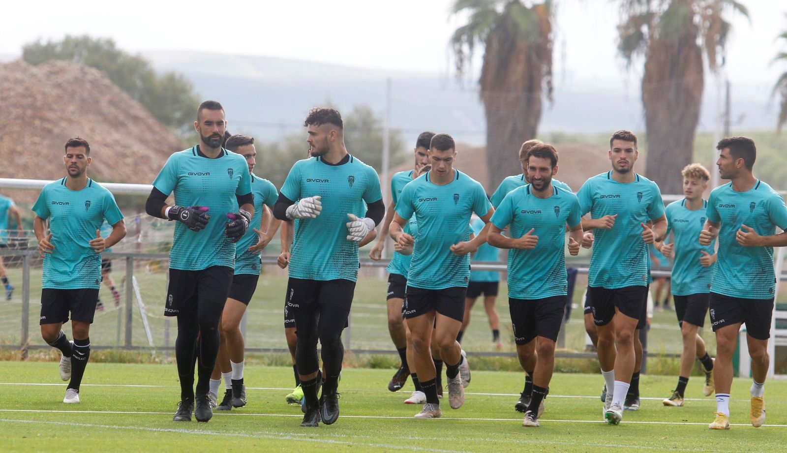Los jugadores del Córdoba CF calientan antes de la sesión de trabajo de este miércoles.