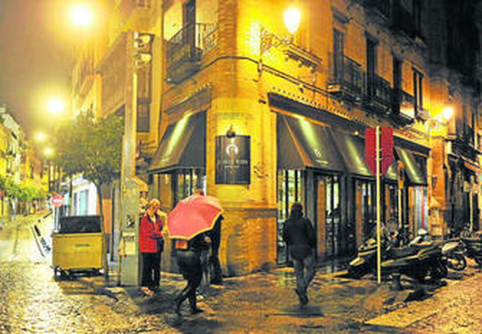 Varios viandantes ante la fachada del bar El Gallo Negro, ayer por la tarde.