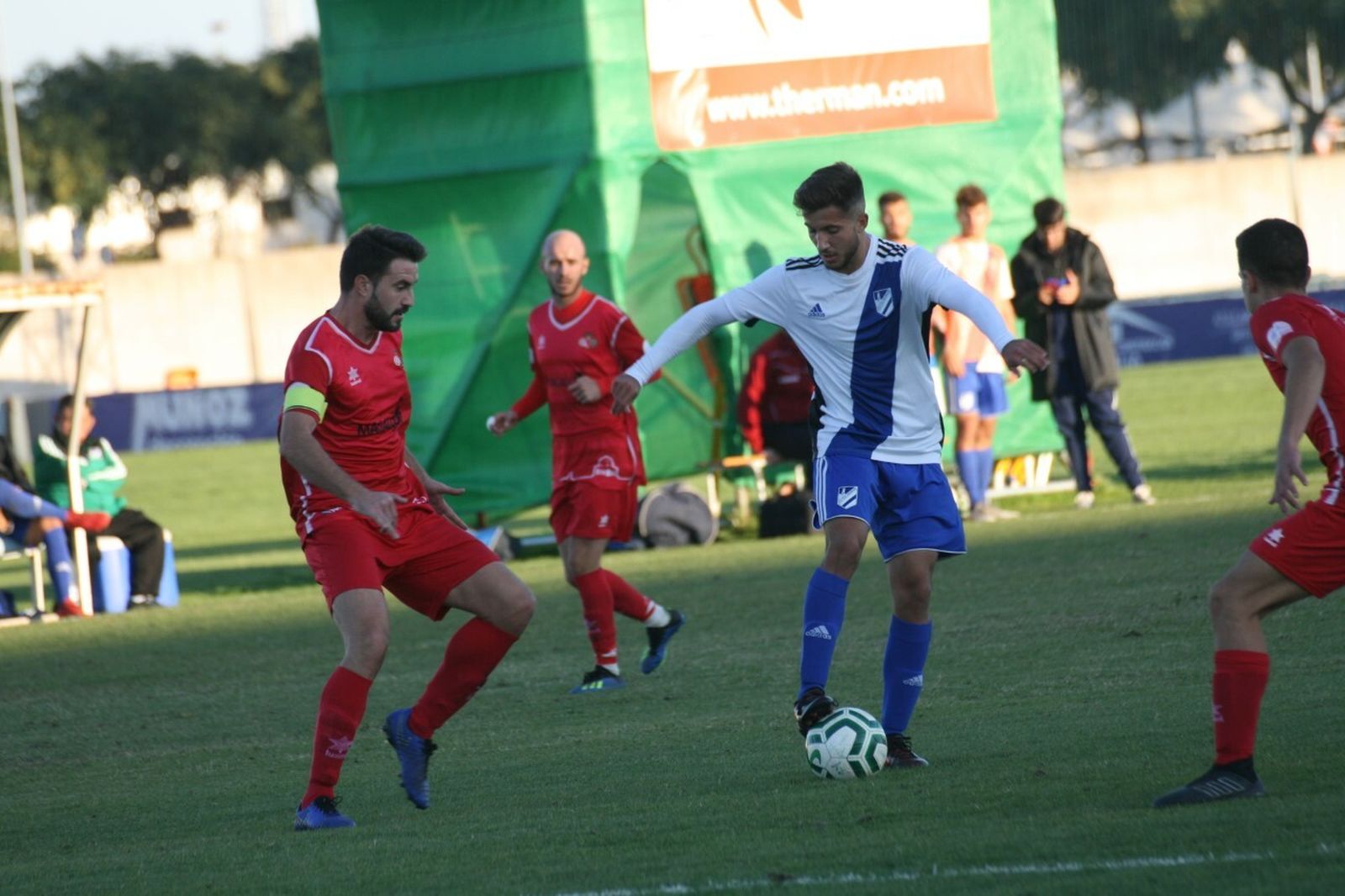Juanma Galán, goleador ante el Chiclana, conduce del balón entre varios rivales, ayer.