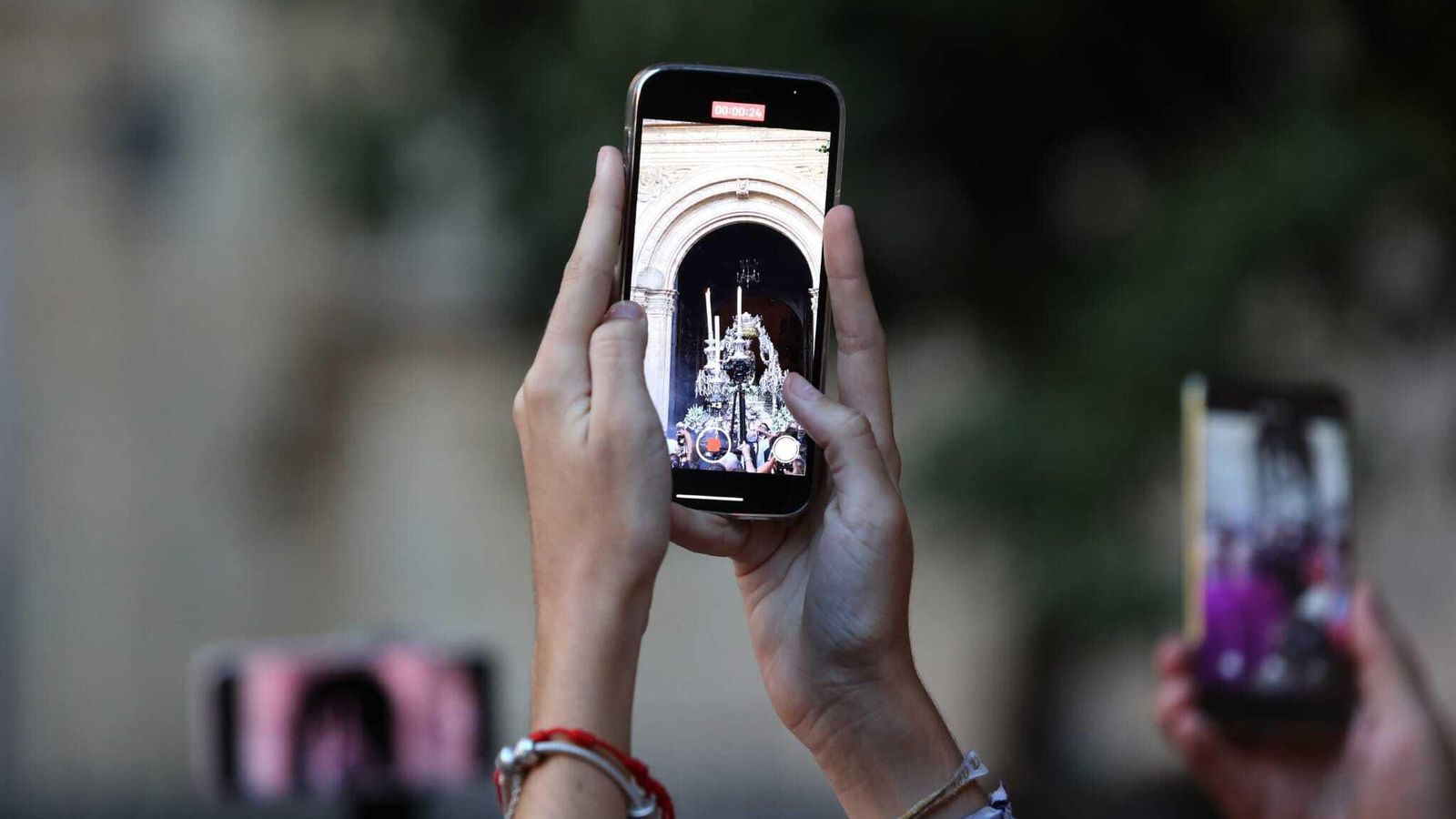 Un devoto usa su móvil para inmortalizar la procesión de la patrona.