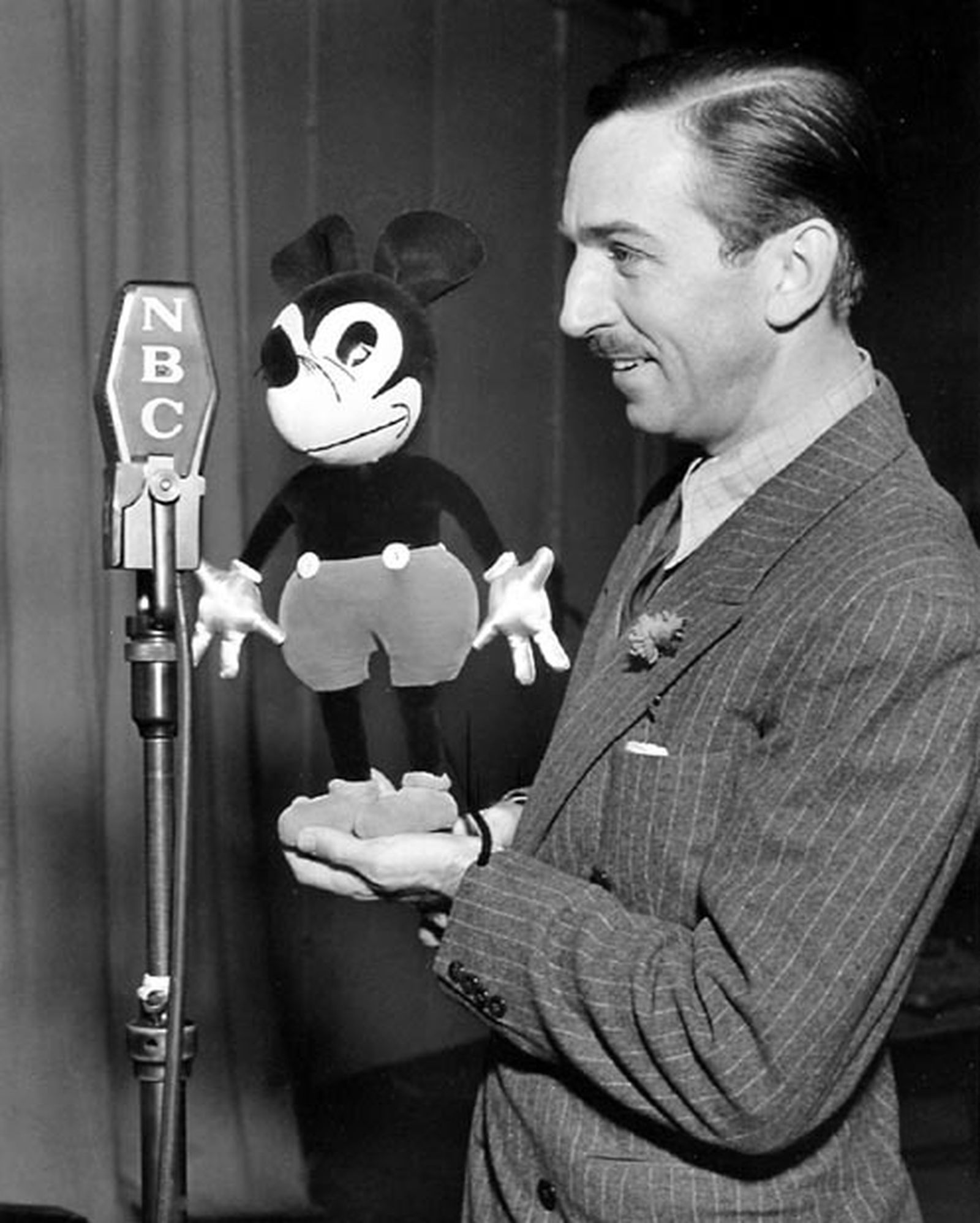 Walt Disney, con un muñeco de una de sus creaciones más conocidas, Mickey Mouse.