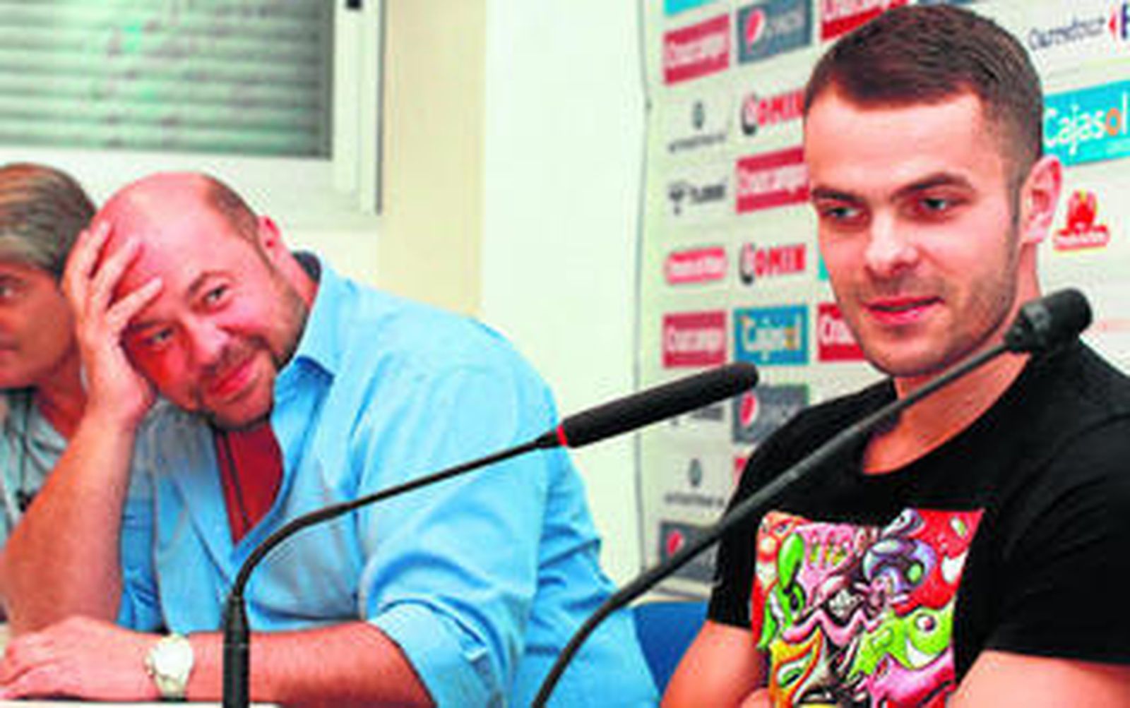 Pablo Comas sonríe mientras Pawel Brozek responde a los medios.