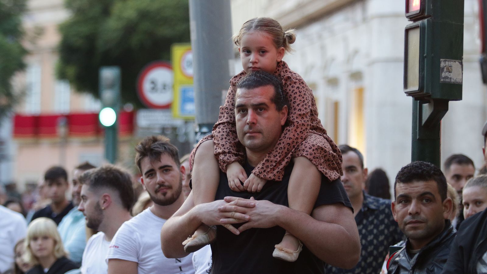 Un padre aúpa a su retoña para que pueda tener una buena visión de la Magna.