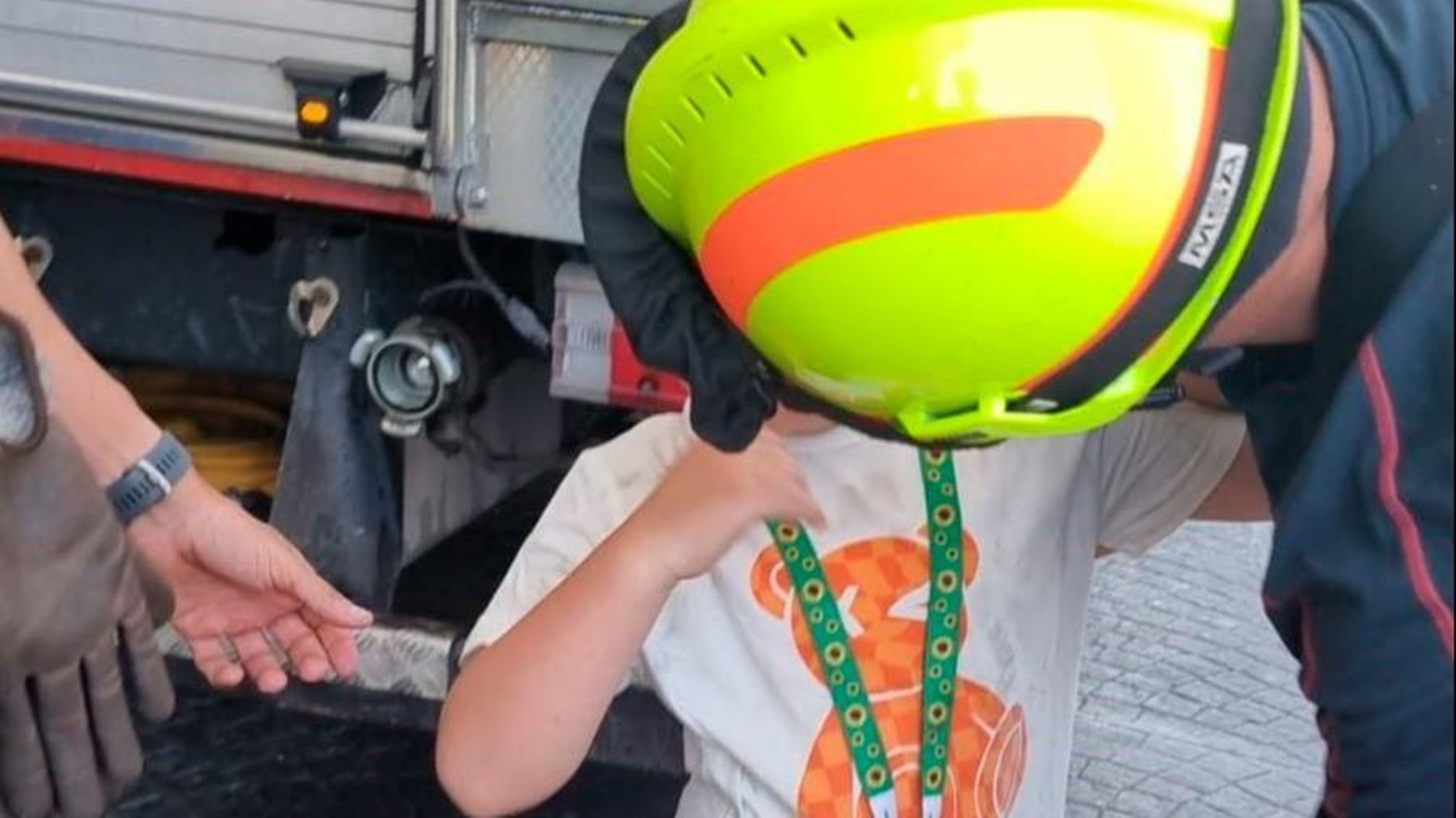 El menor junto a uno de los bomberos que lo socorrió.