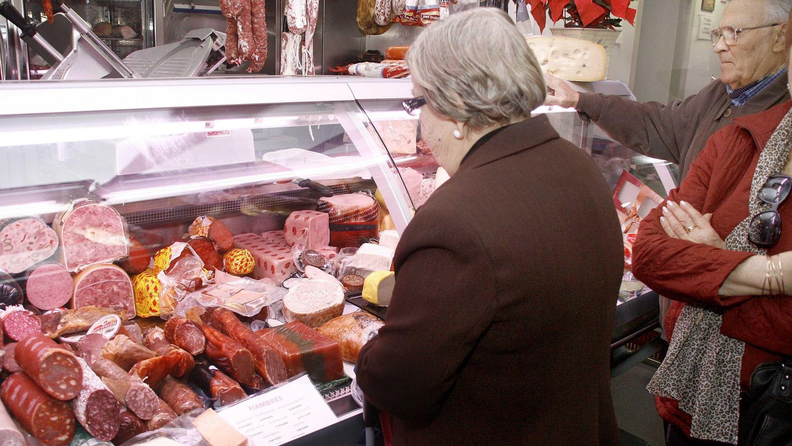 Una mujer mira el escaparate de una charcutería