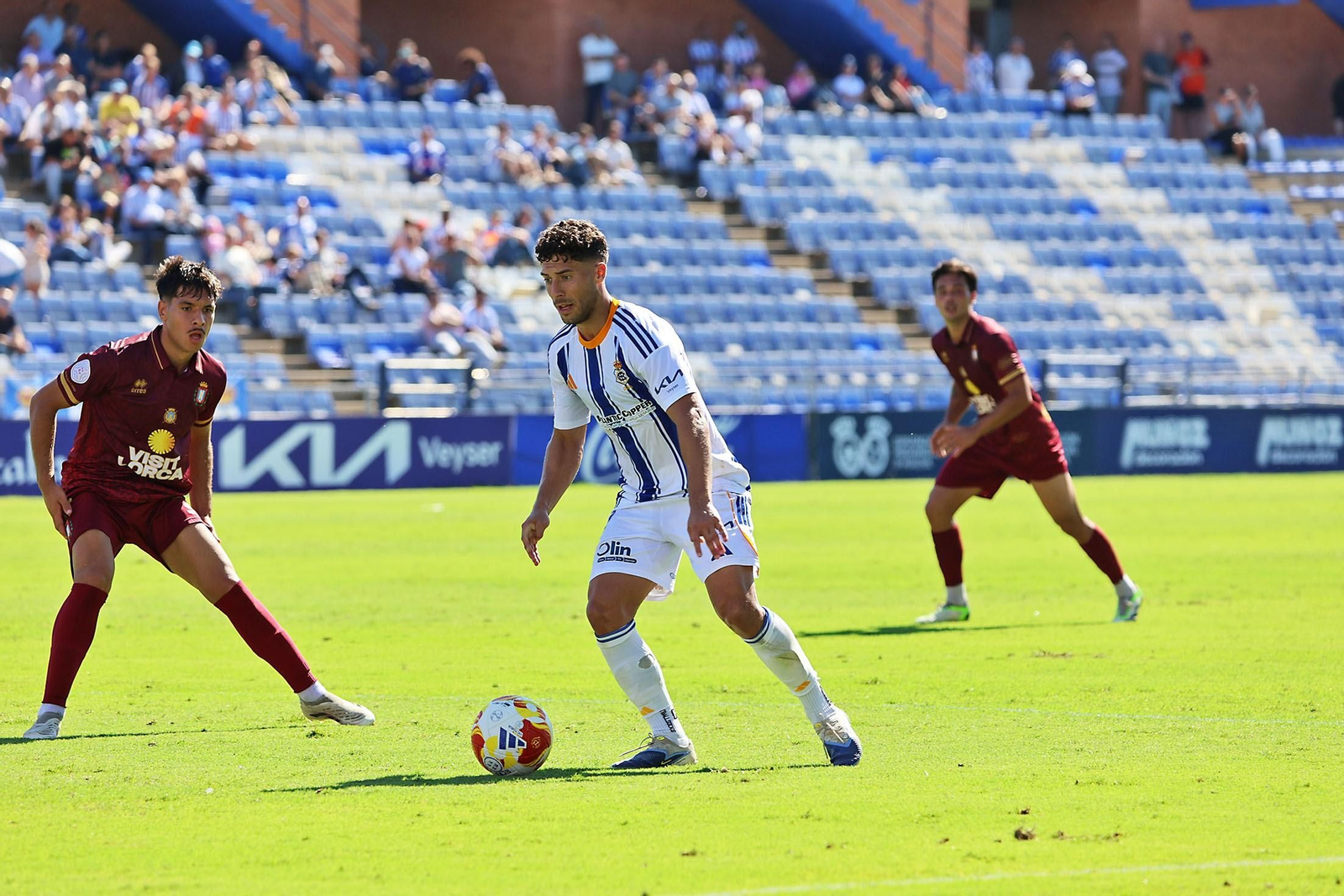 Pepe Mena, observado por dos jugadores del Lorca Deportiva.