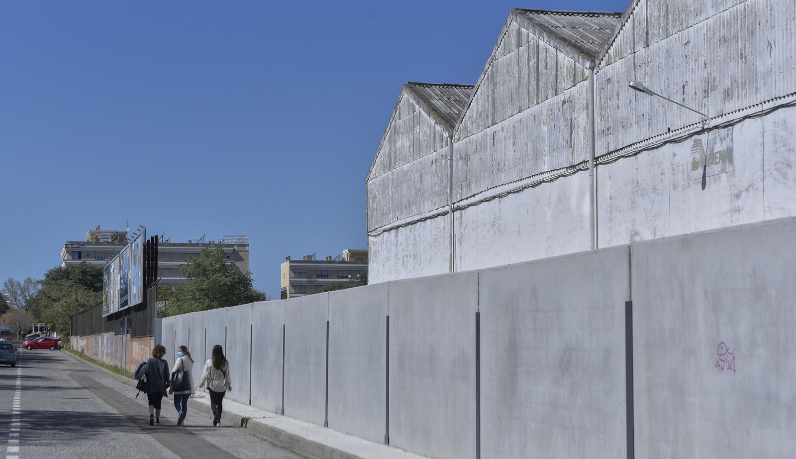 Varias vecinas por el lateral de la  algodonera de la calle Almendralejo. Al fondo, edificios que dan a la fachada principal de la fábrica, en la calle Secoya.