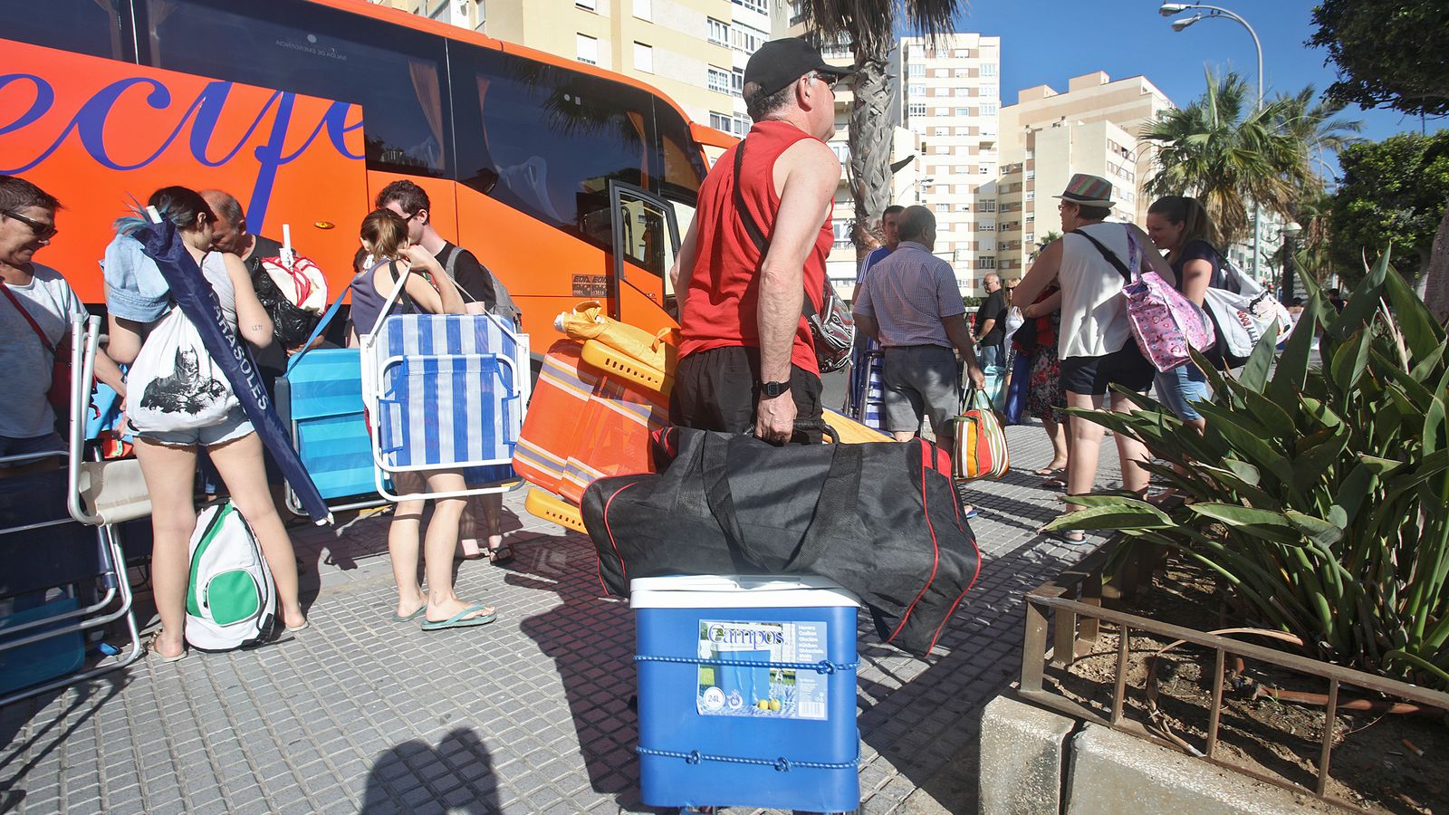 Varias personas se bajan del autobús que los deja en la parada de Cádiz.