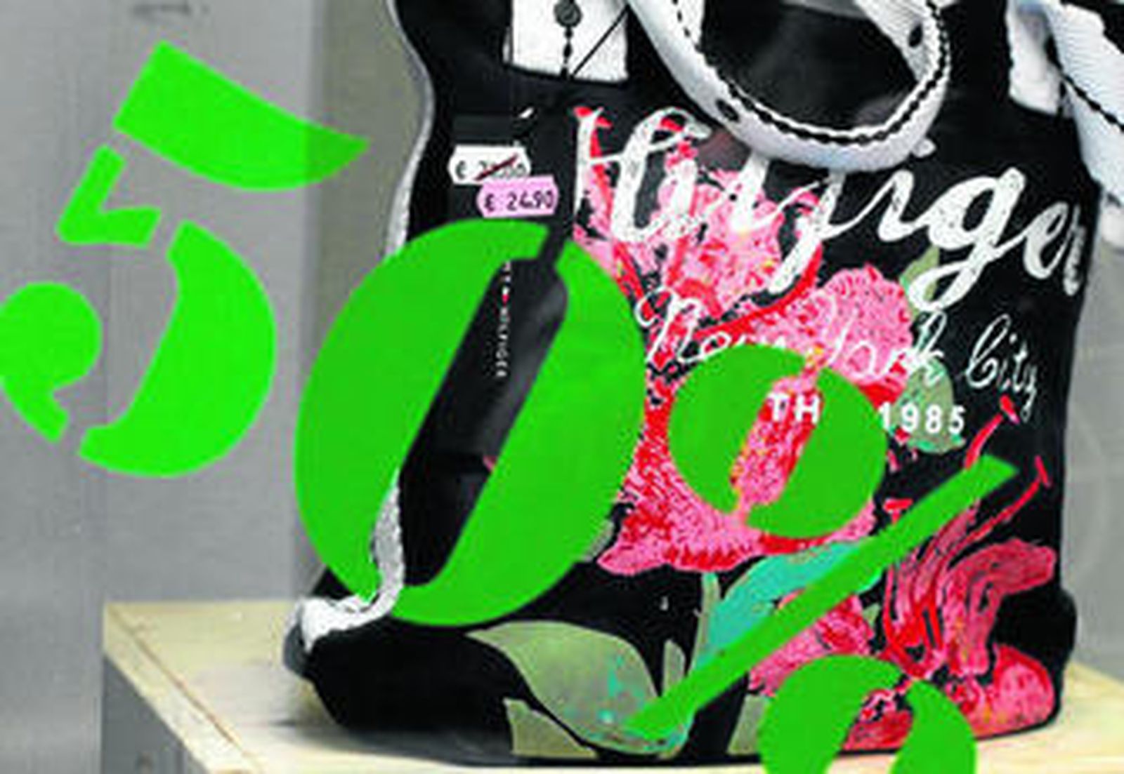 Escaparate de un comercio 'outlet' del centro de Cádiz con una oferta impresa.