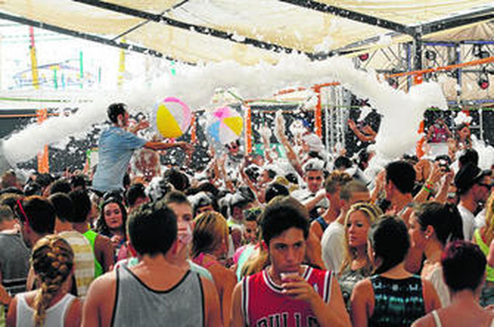 Jóvenes durante la fiesta de la espuma, ayer en la caseta de Europa FM, en la zona de bares y discotecas del Real.