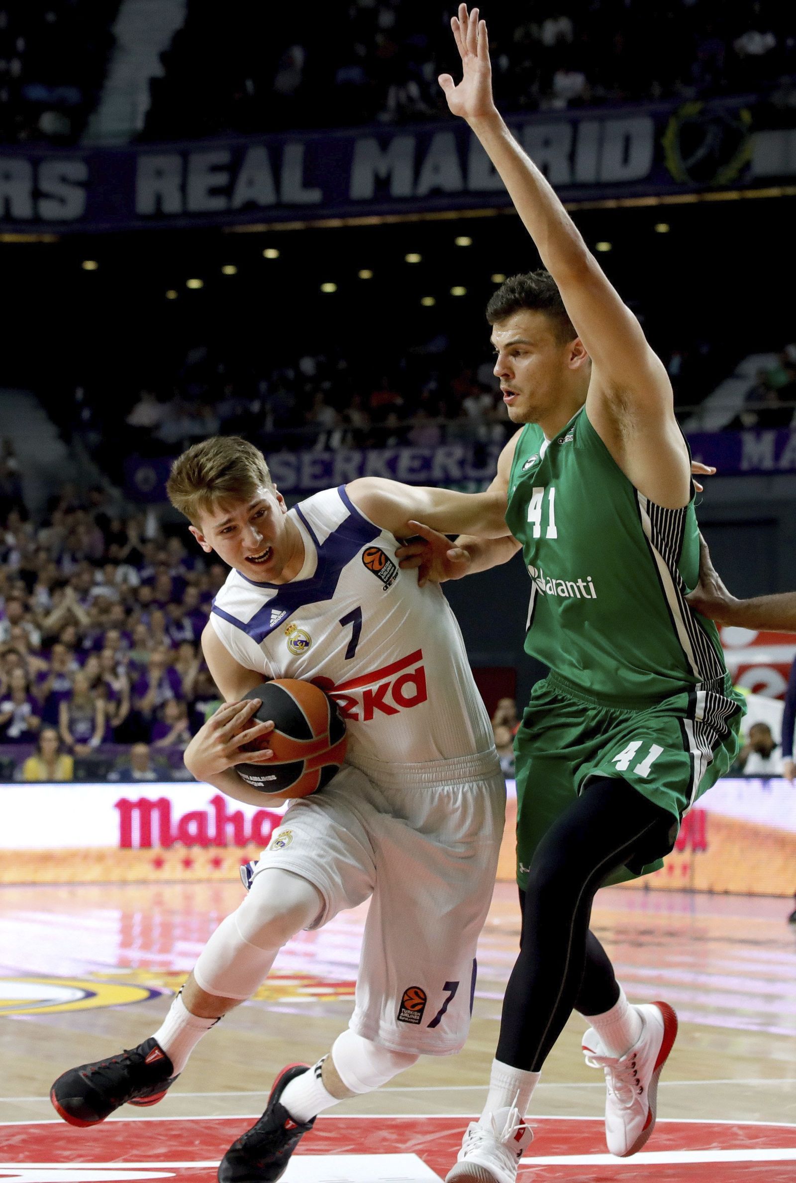 Doncic trata de penetrar a canasta defendido por Zizic.