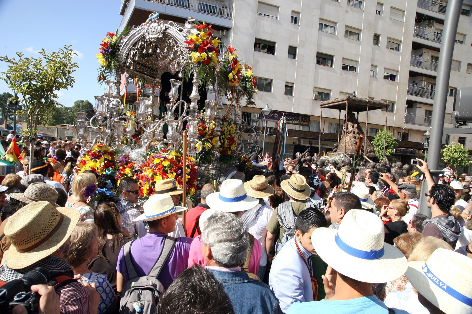 El Simpecado de la Hermandad de Emigrantes ante el monumento a la Virgen del Rocío en El Punto.