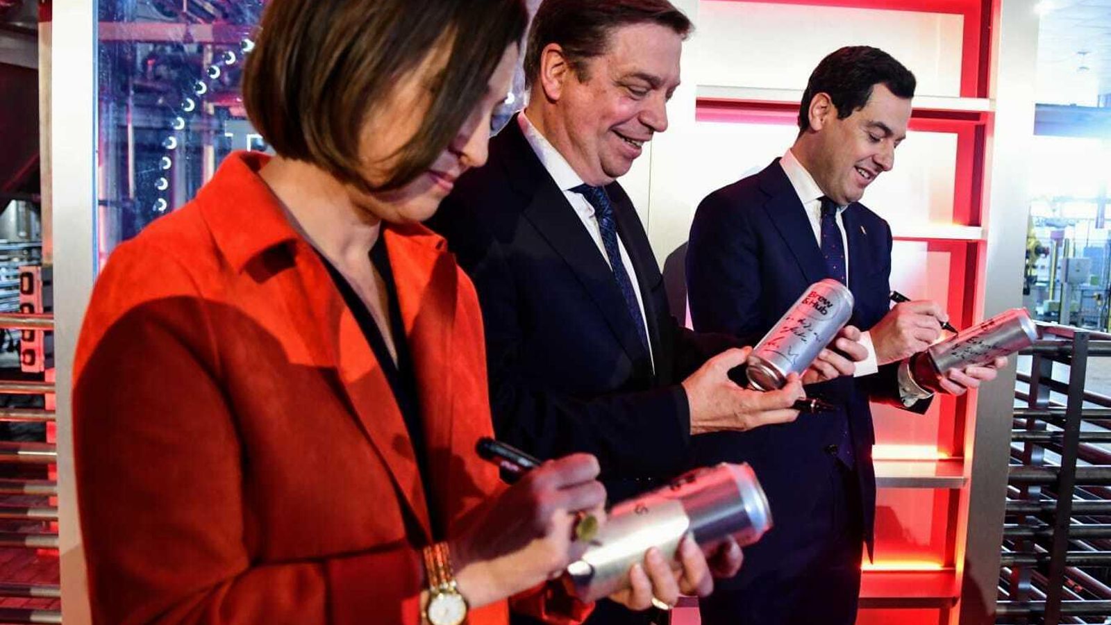 Ambrosio, Planas y Moreno firman una lata de cerveza.