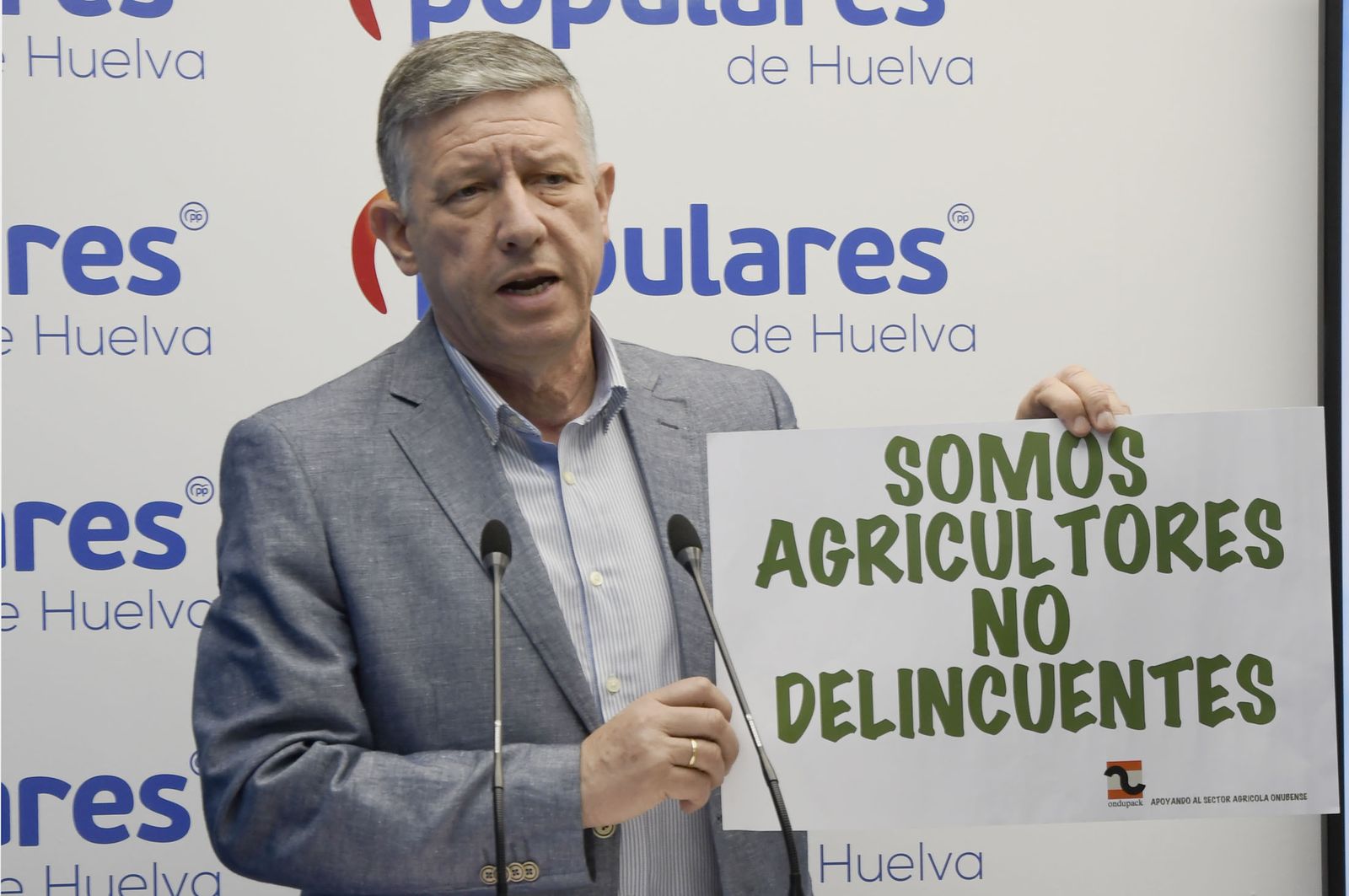 Carmelo Romero sostiene un cartel durante la rueda de prensa de ayer.