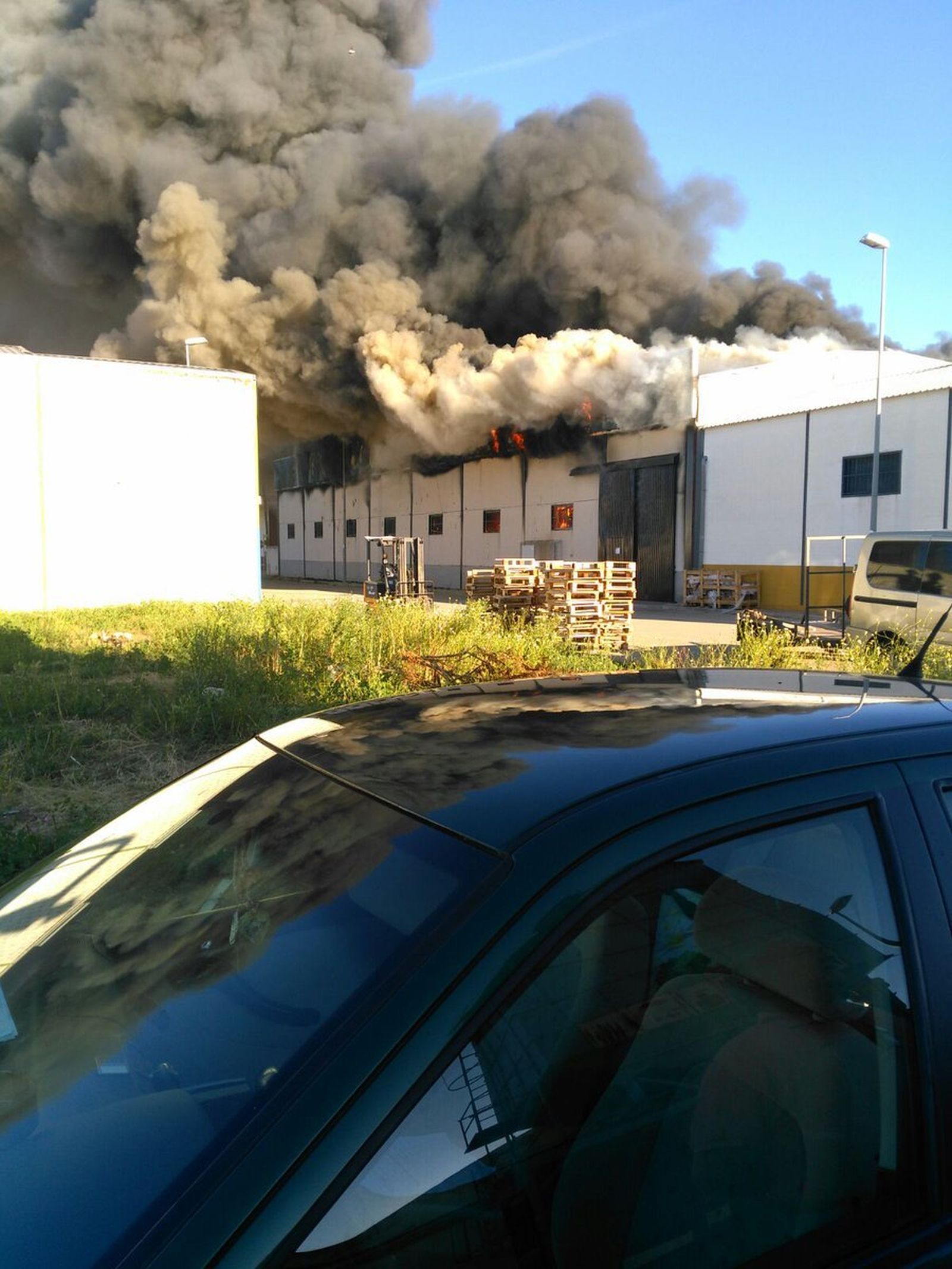 Una intensa humareda sale de las naves incendiadas.