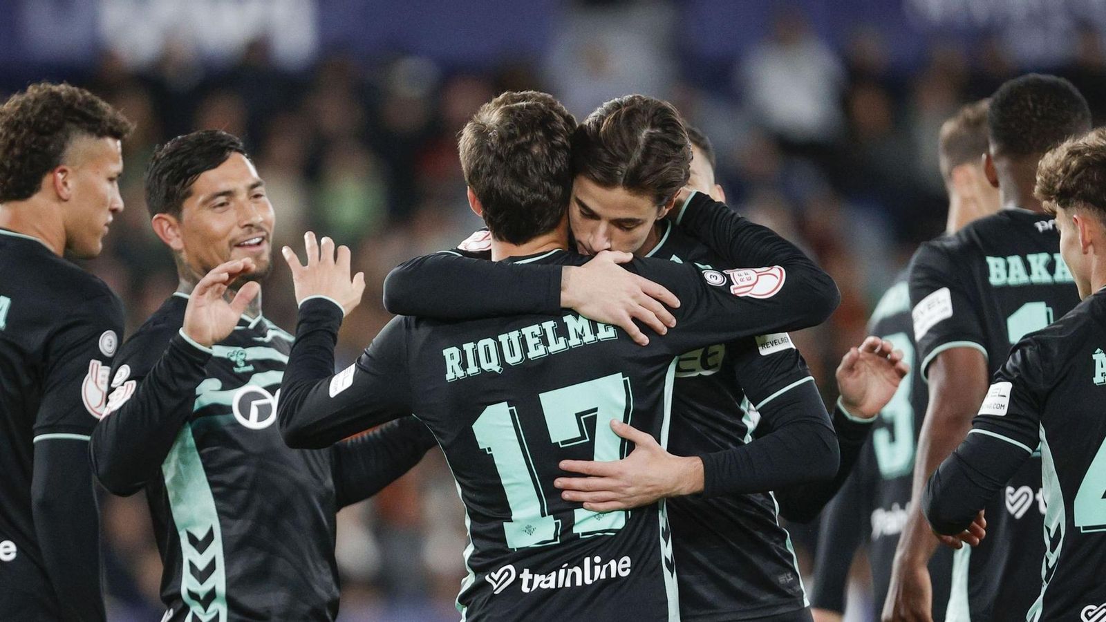 El trigoleador Riquelme recibe el abrazo de Valentín Gómez entre la celebración de todos los béticos.