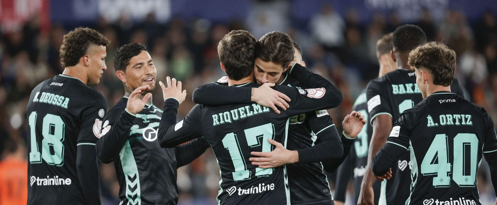 El trigoleador Riquelme recibe el abrazo de Valentín Gómez entre la celebración de todos los béticos.