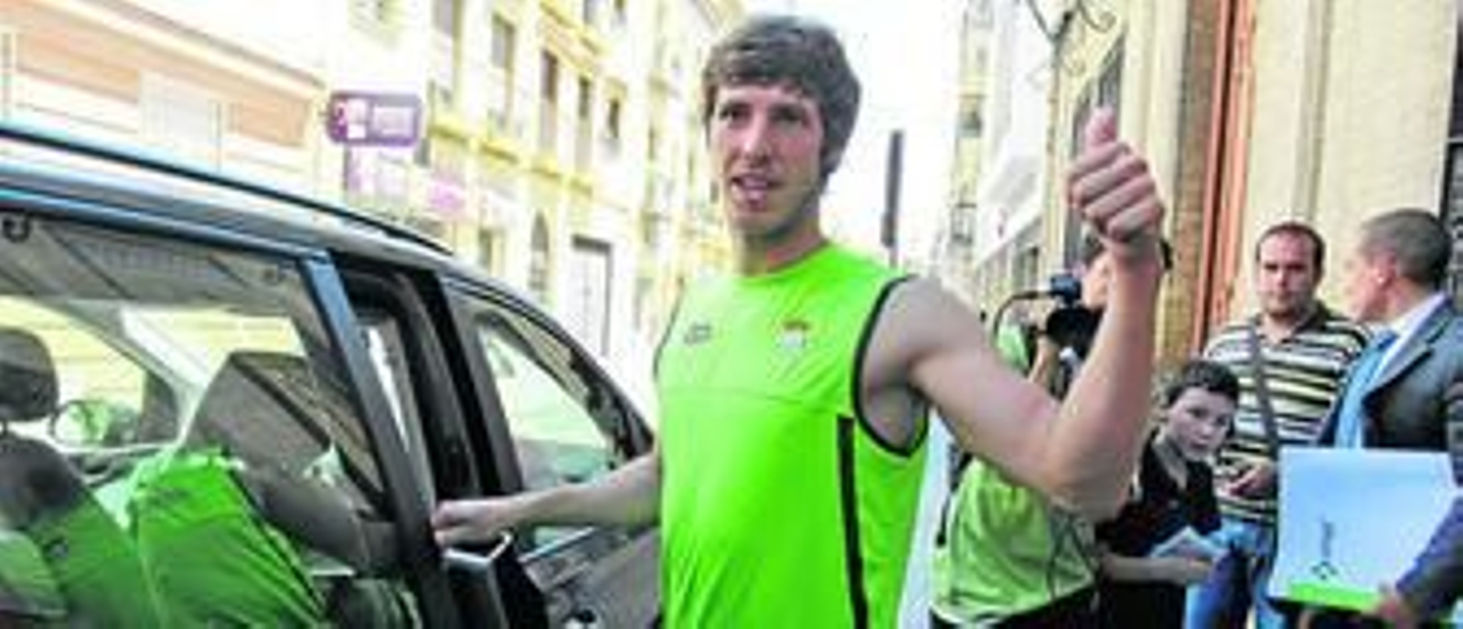 Rubén Pérez da el OK con su pulgar izquierdo tras abandonar la clínica Infanta Luisa por la puerta lateral; con carpeta blanca, quien intentó ocultarlo a la prensa.