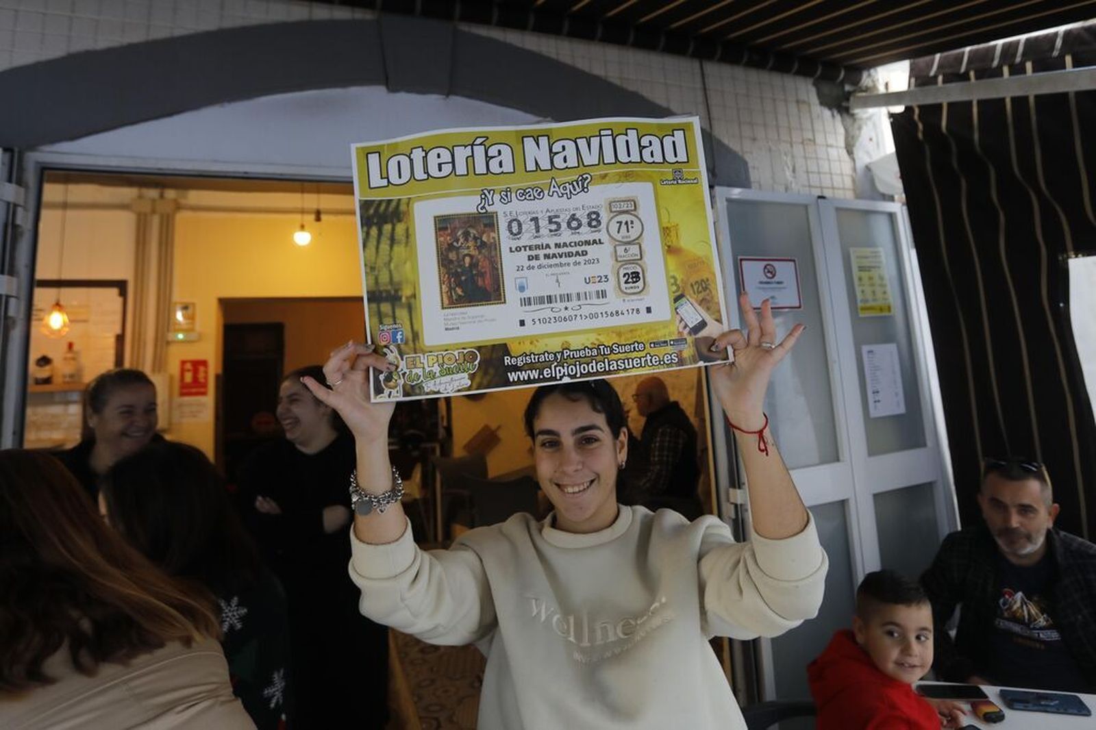 Una agraciada muestra el anuncio que incitaba a comprar el número premiado en El Piojo de la Suerte