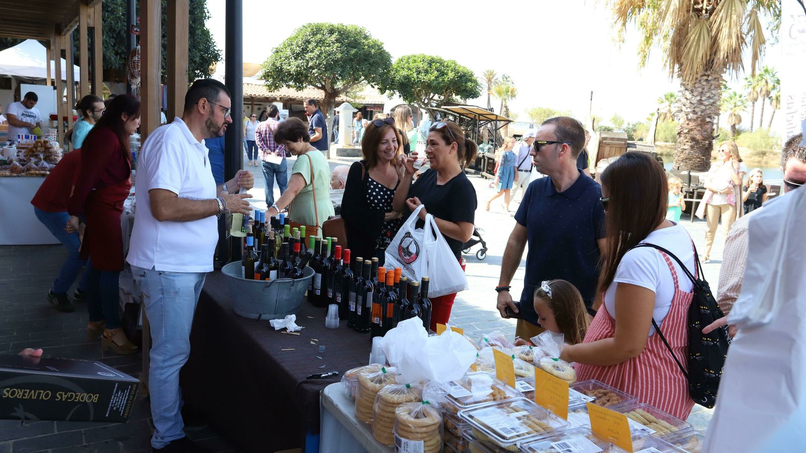 Varias personas compran productos de la gastronomía onubense.