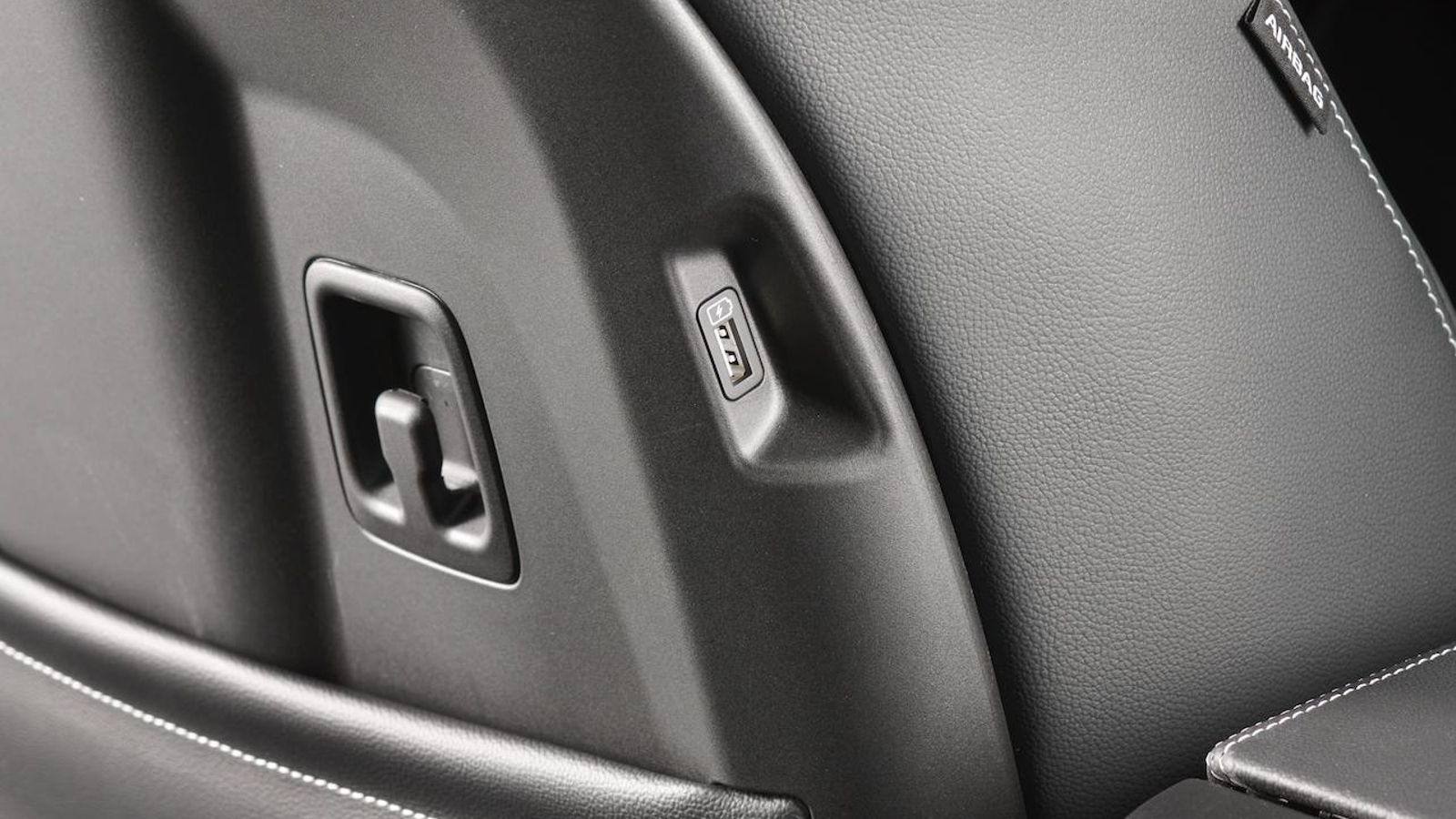 Kia ha convertido los enveses de los respaldos delanteros en zonas polifuncionales con ganchos, bolsas, punto de carga USB o colgadores de chaquetas.