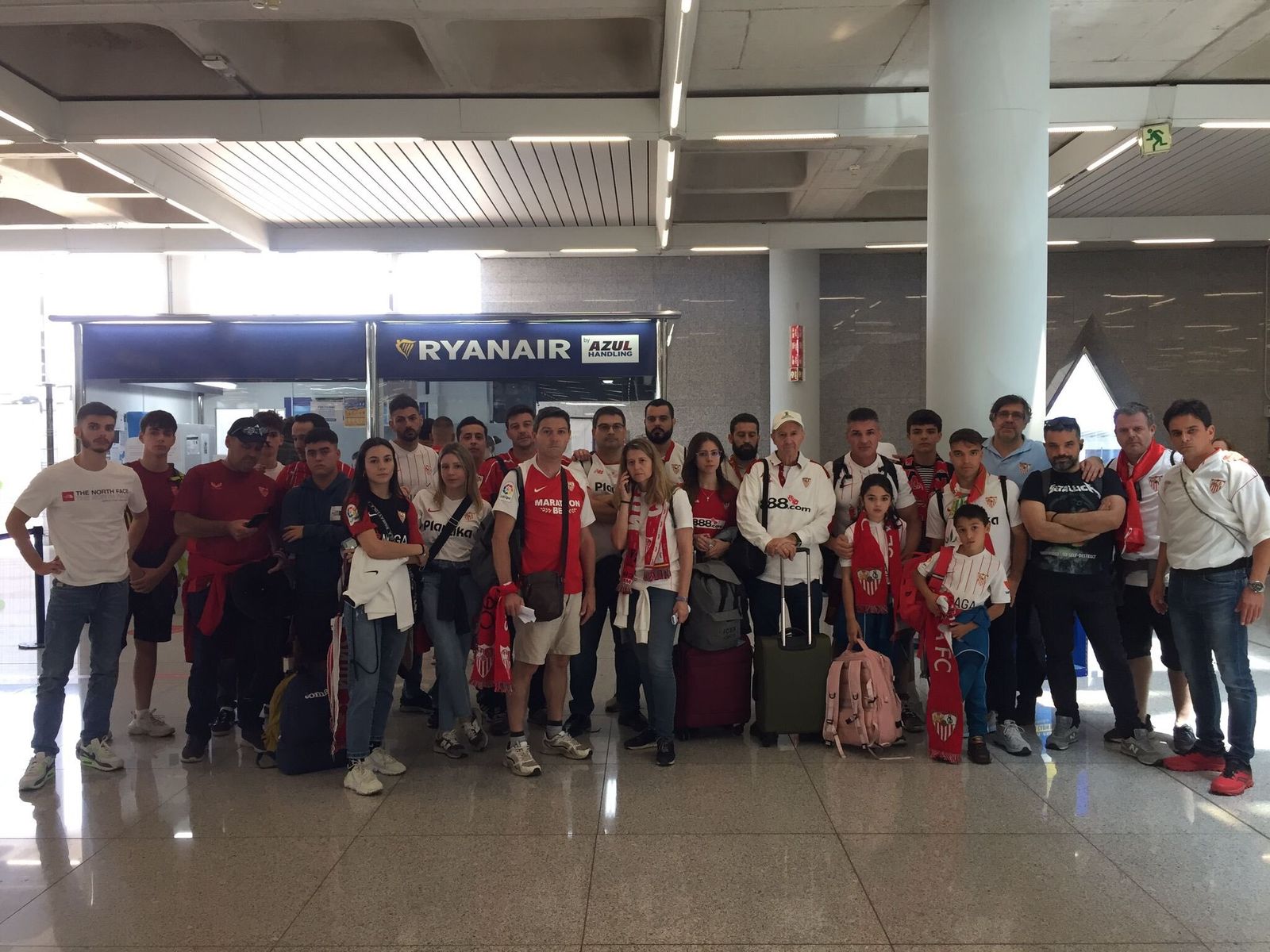 Un grupo de los sevillistas estancados en Palma de Mallorca, ante un despacho de Ryanair.
