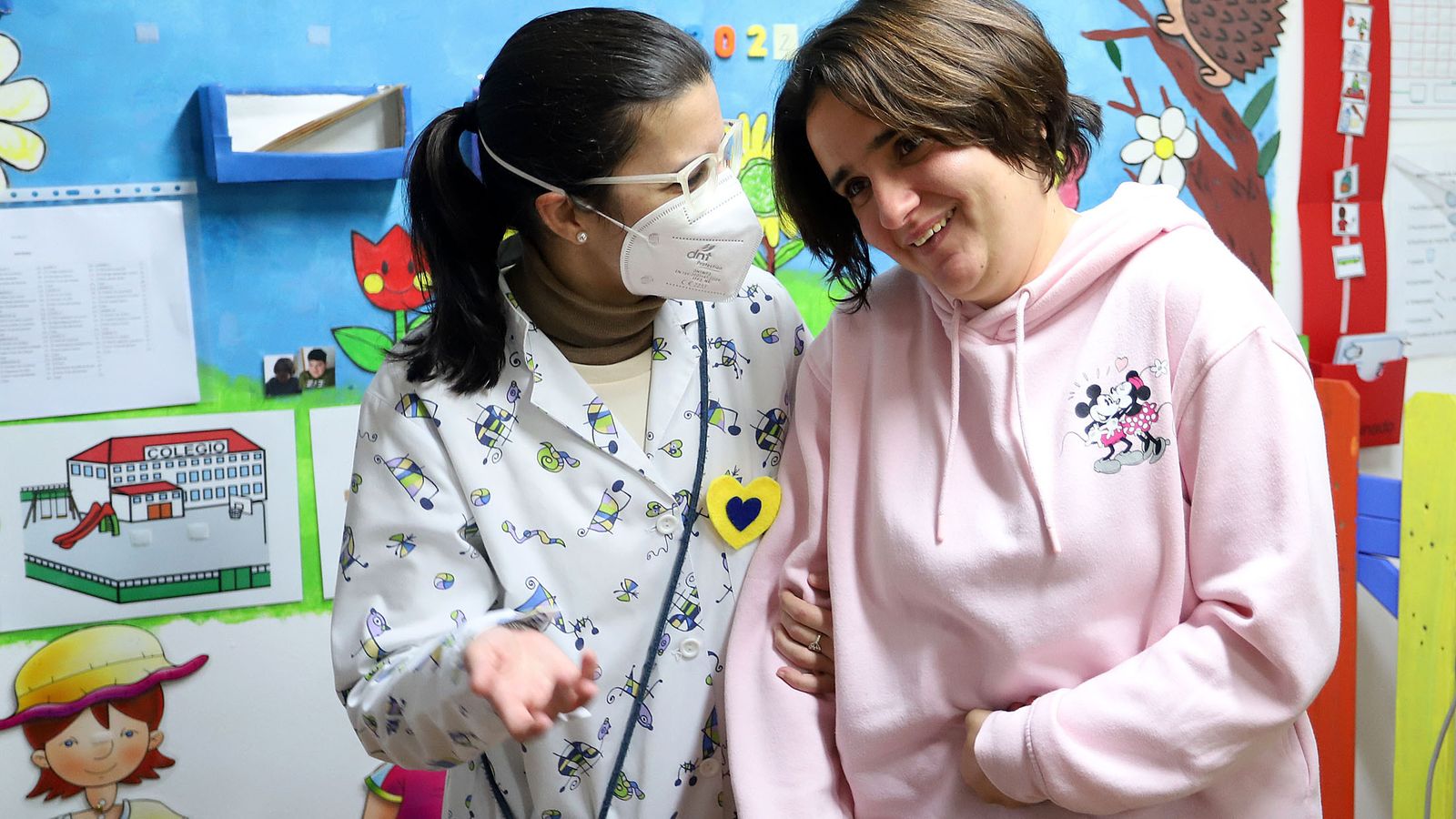 Sara posa sonriente junto a su profesora.