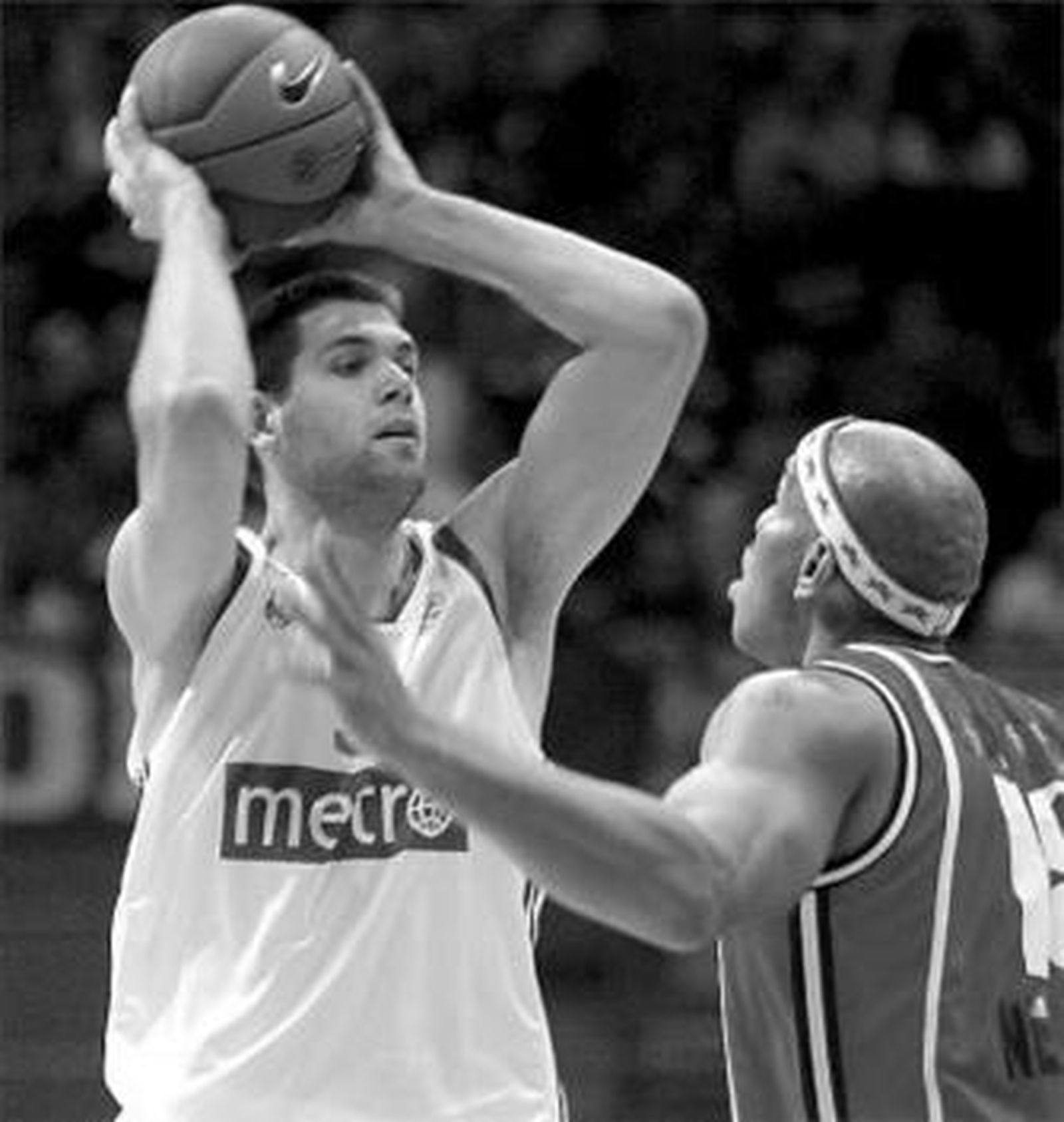 Felipe Reyes trata de pasar la pelota en presencia de Baxter.