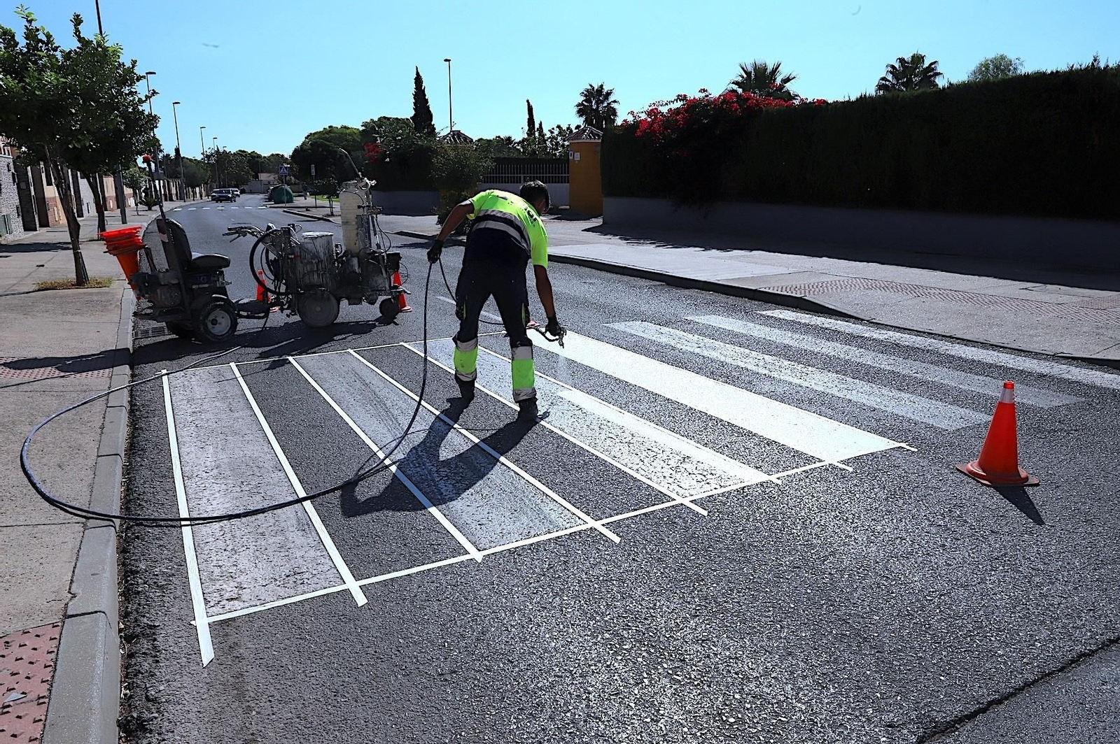 Un operario, pintando un paso de peatones.