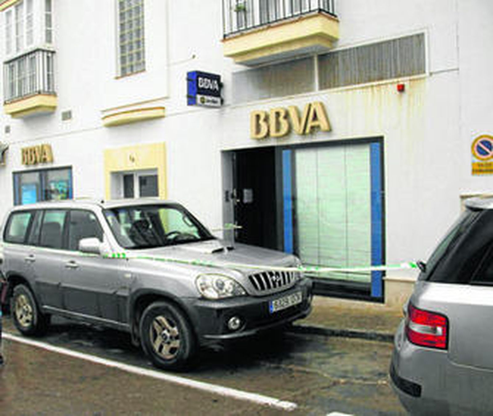 Precinto de la Guardia Civil ante la oficina bancaria asaltada, en la calle Laguna de Conil.