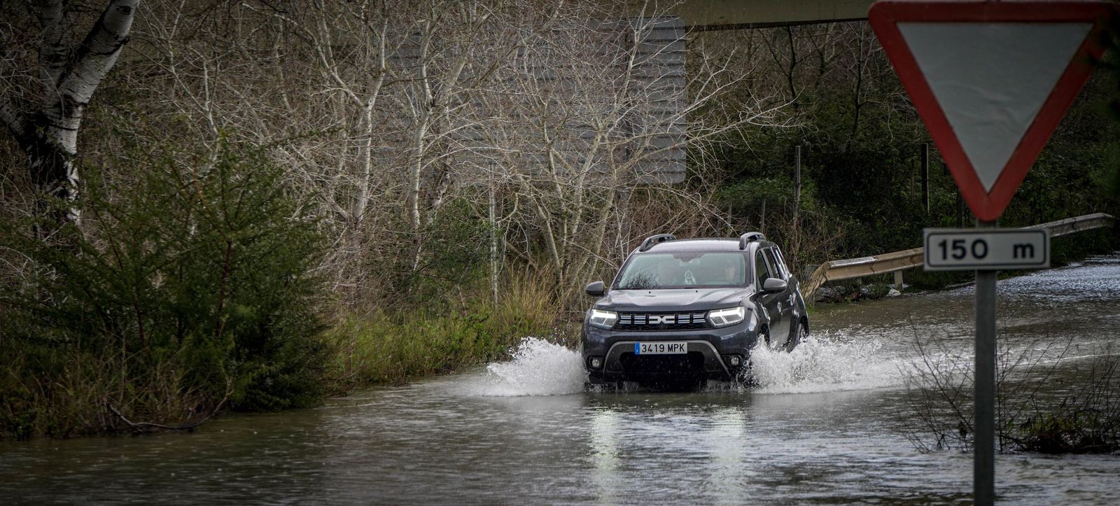 Un coche pasa por una carretera llena de agua, este martes.
