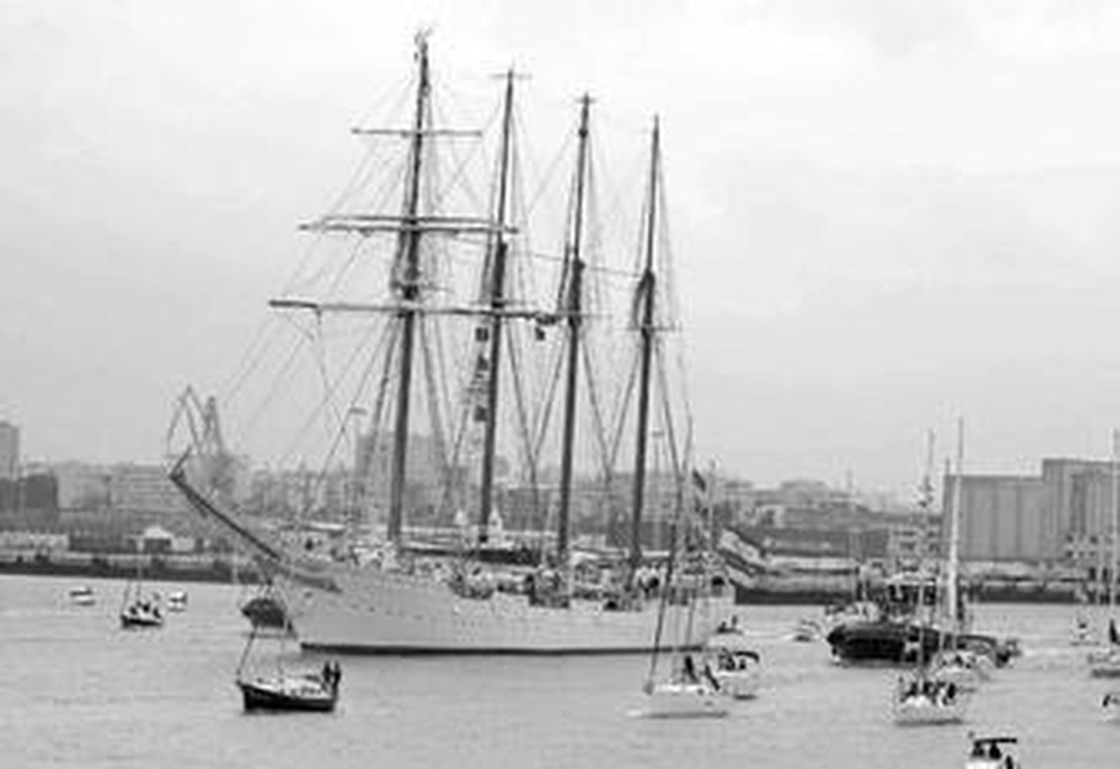 El 'Juan Sebastián Elcano' se dirige a la salida del puerto de Cádiz acompañado por diversas embarcaciones.
