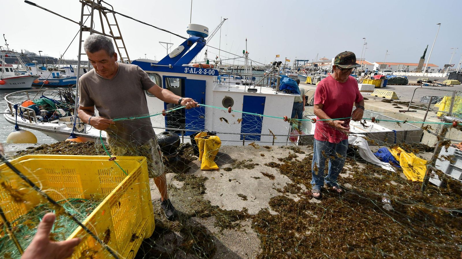 Pescadores de Tarifa limpiando las redes de algas.