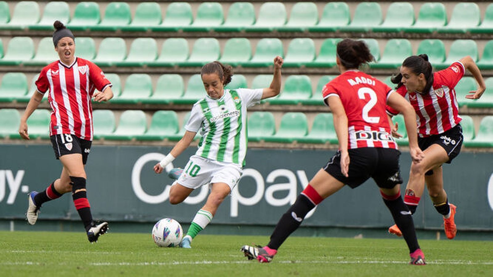 Rosa Márquez golpea el balón rodeada por tres rivales.