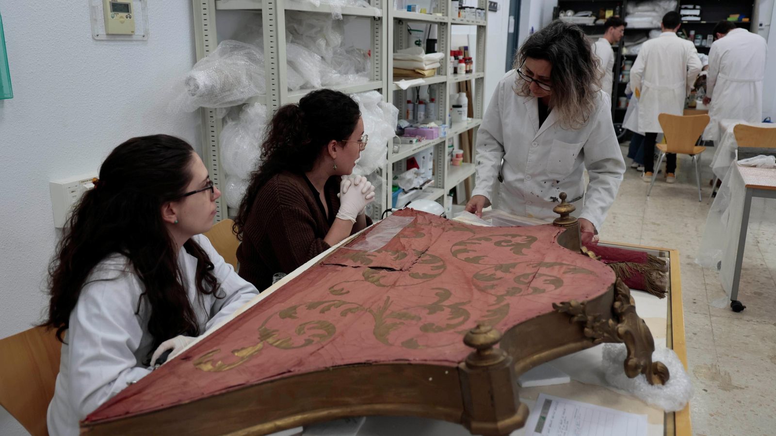 La profesora Elena Vázquez con las alumnas que reparan el dosel.
