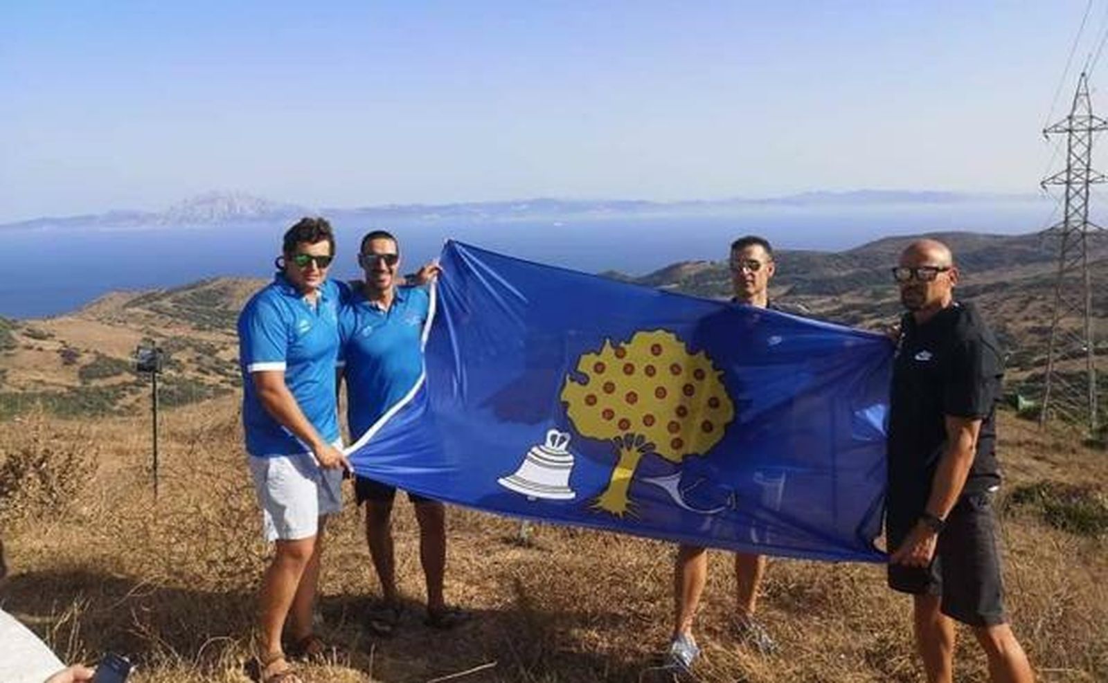 Los cuatro nadadores, con la bandera de Navalmoral de la Mata, antes de iniciar la travesía