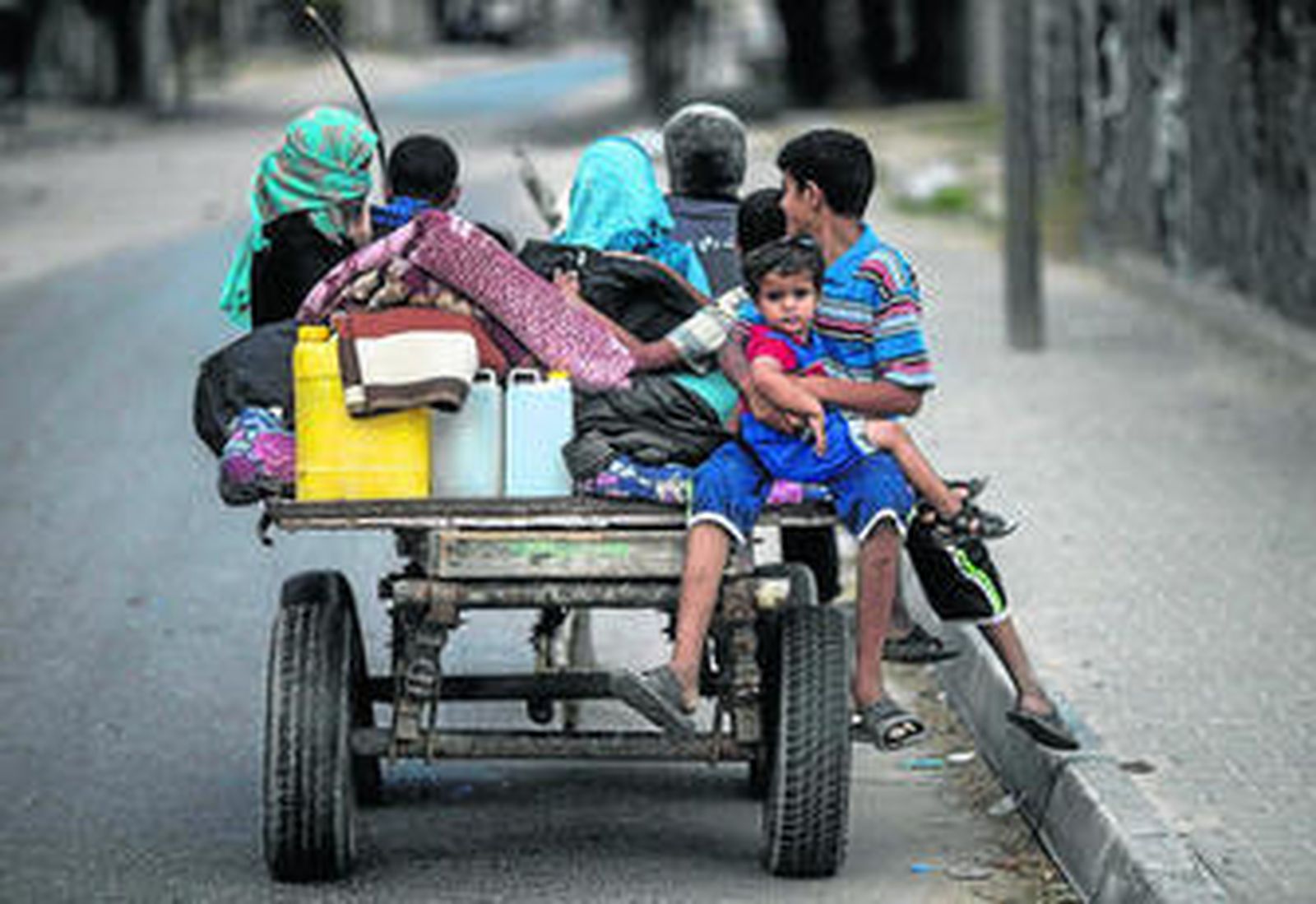 Una familia palestina huye de su casa y busca refugio en un colegio de la ONU en Jan Yunes.