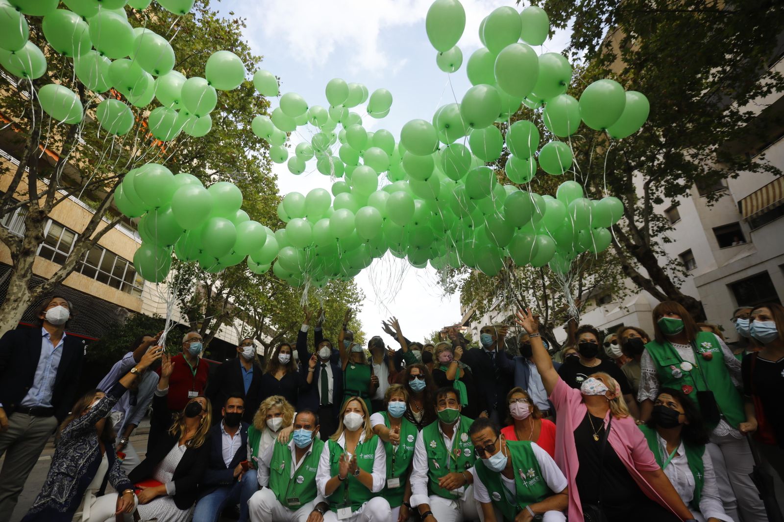 Voluntarios y representantes institucionales en la suelta de globos de la AECC.