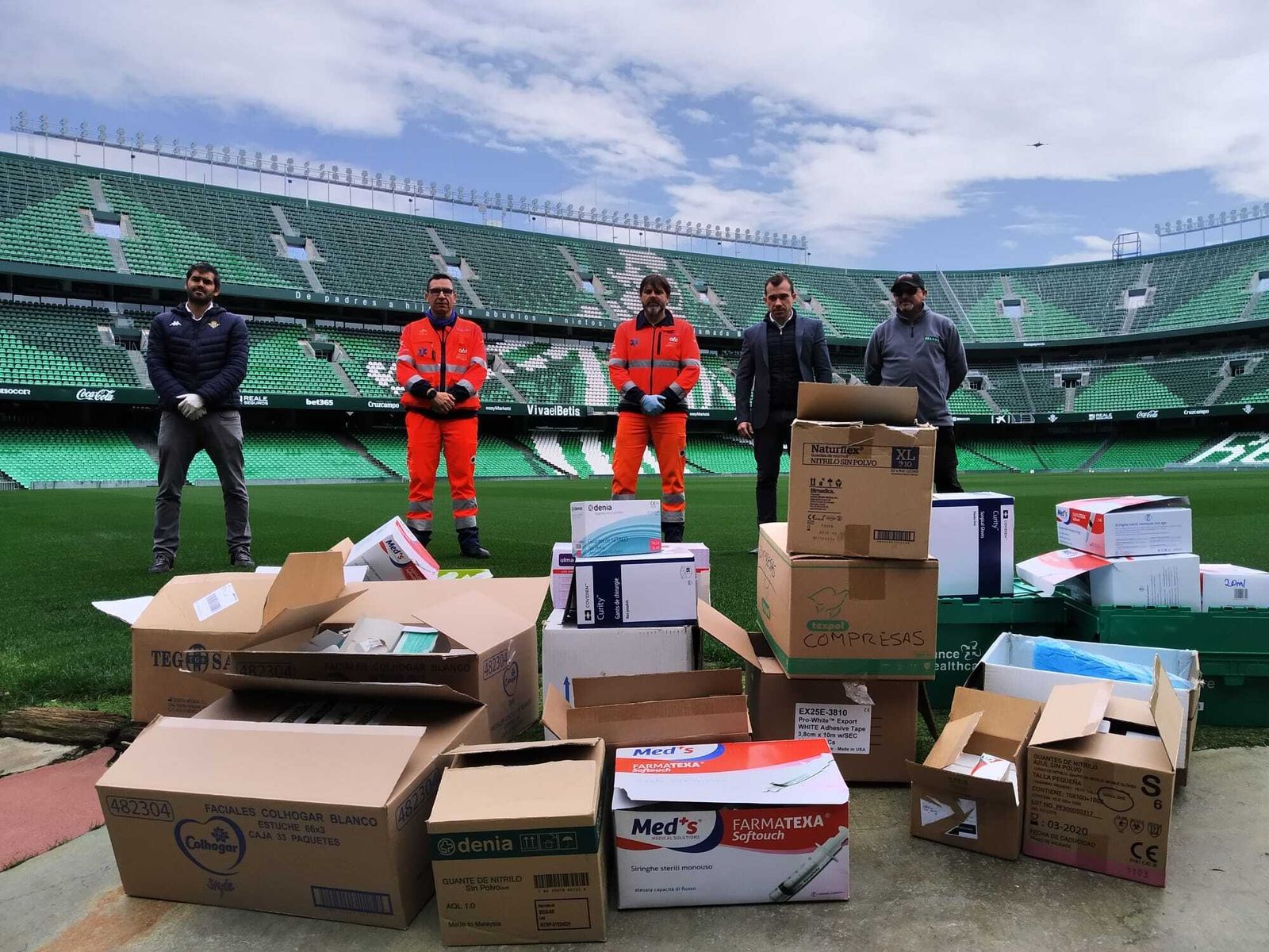 Empleados del Betis entregan el material sanitario.