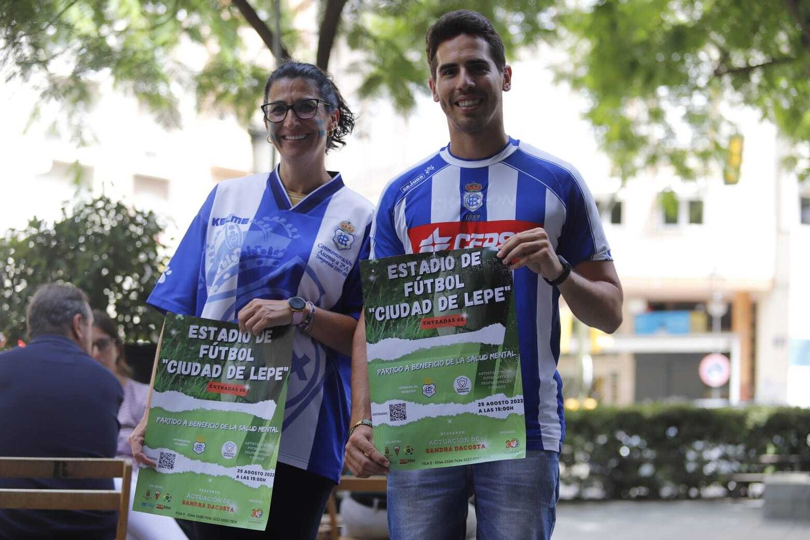 Dos jóvenes con el cartel del partido solidario organizado por Feafes.