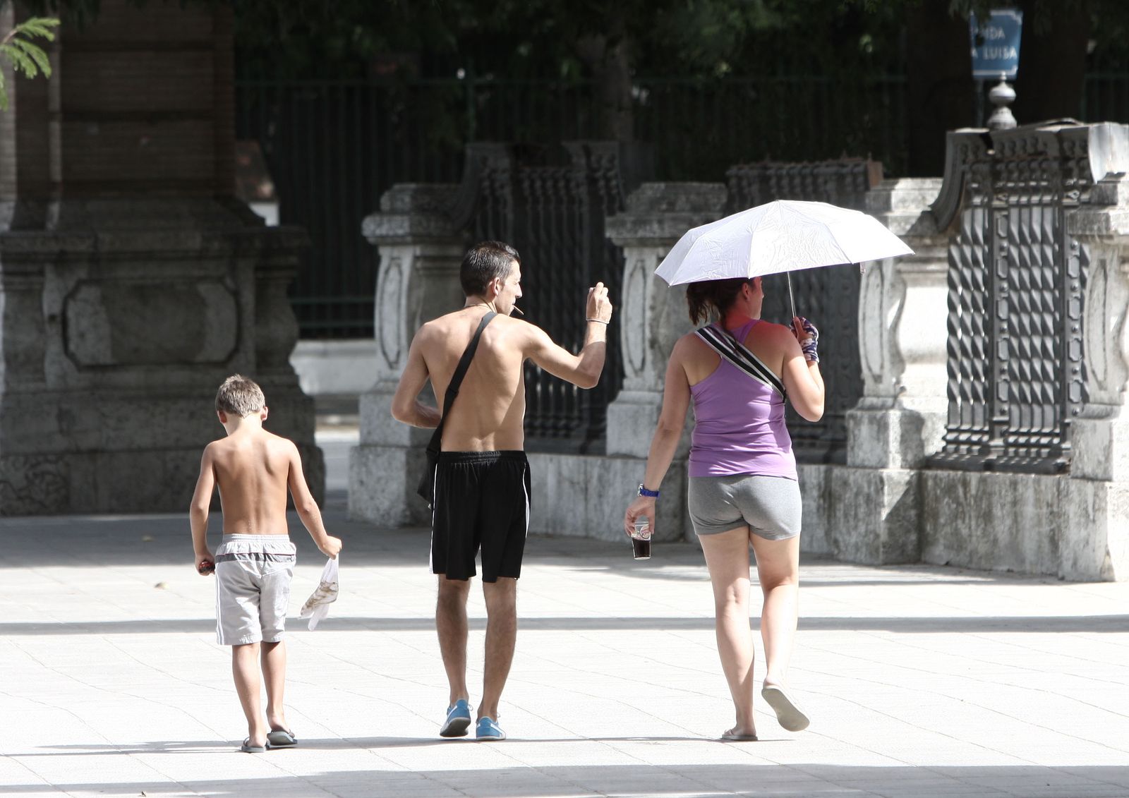 Turistas pasean por Sevilla a pleno sol.